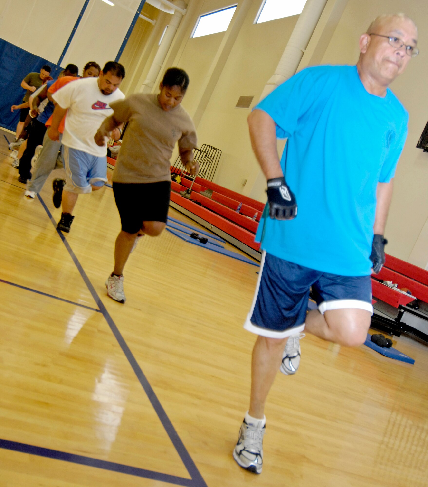 VANDENBERG AIR FORCE BASE, Calif. - Bernardo Jamorabo, from the 30th Range Management Squadron, along with the group of attendees at the Hardcore 30-Minute Workout do line hurdles here Tuesday, May 18, 2010. The workout program exercise varies depending on the trainer and the day. (U.S. Air Force photo/Senior Airman Andrew Lee)