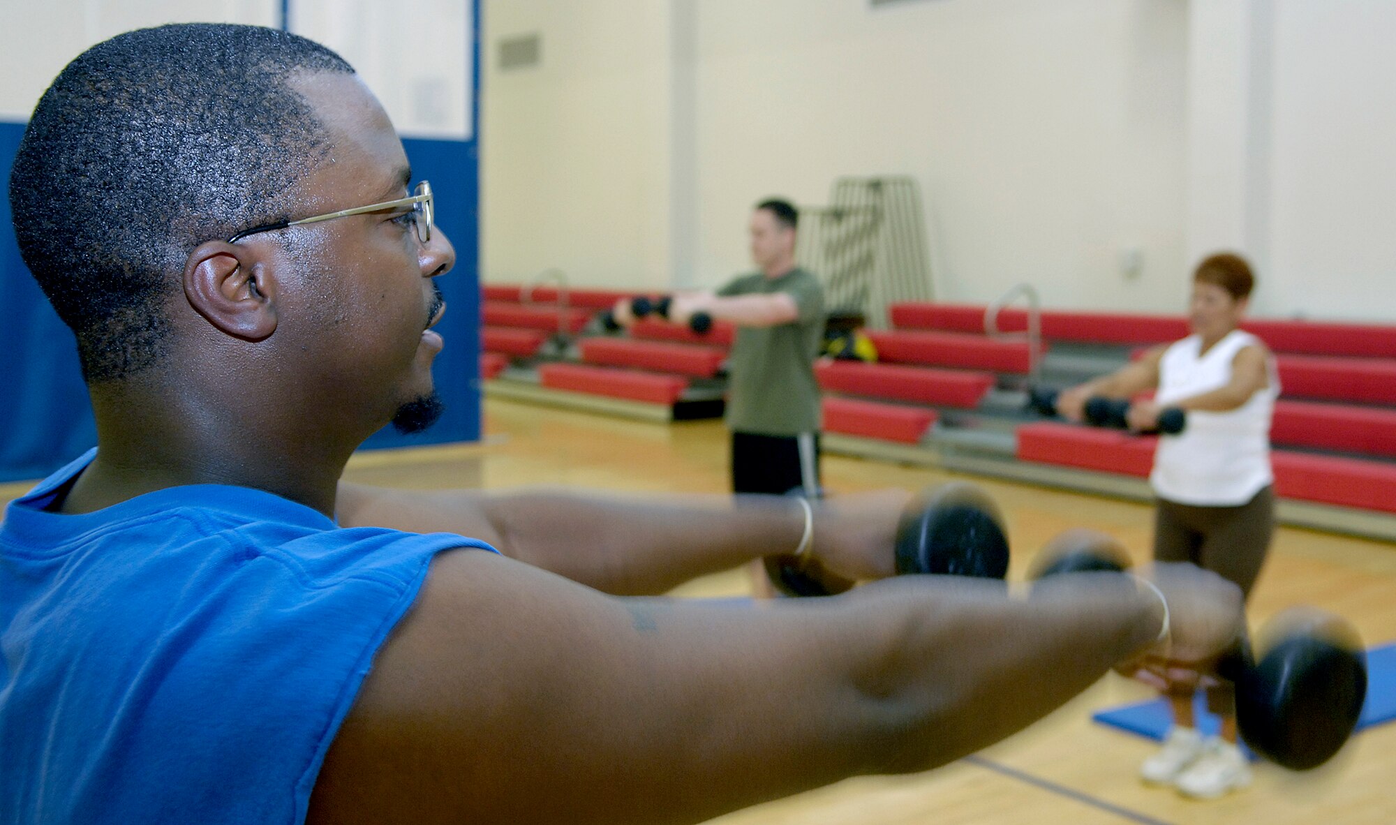 VANDENBERG AIR FORCE BASE, Calif. - Leading the Hardcore 30 Minute Workout  Anthony Sullivan, a sports fitness aid for the base fitness center, shows how to properly do arm raise exercises with weights here Tuesday, May 18, 2010. The workout program is provided at the base fitness center at lunchtime from noon to 12:30 p.m. (U.S. Air Force photo/Senior Airman Andrew Lee)