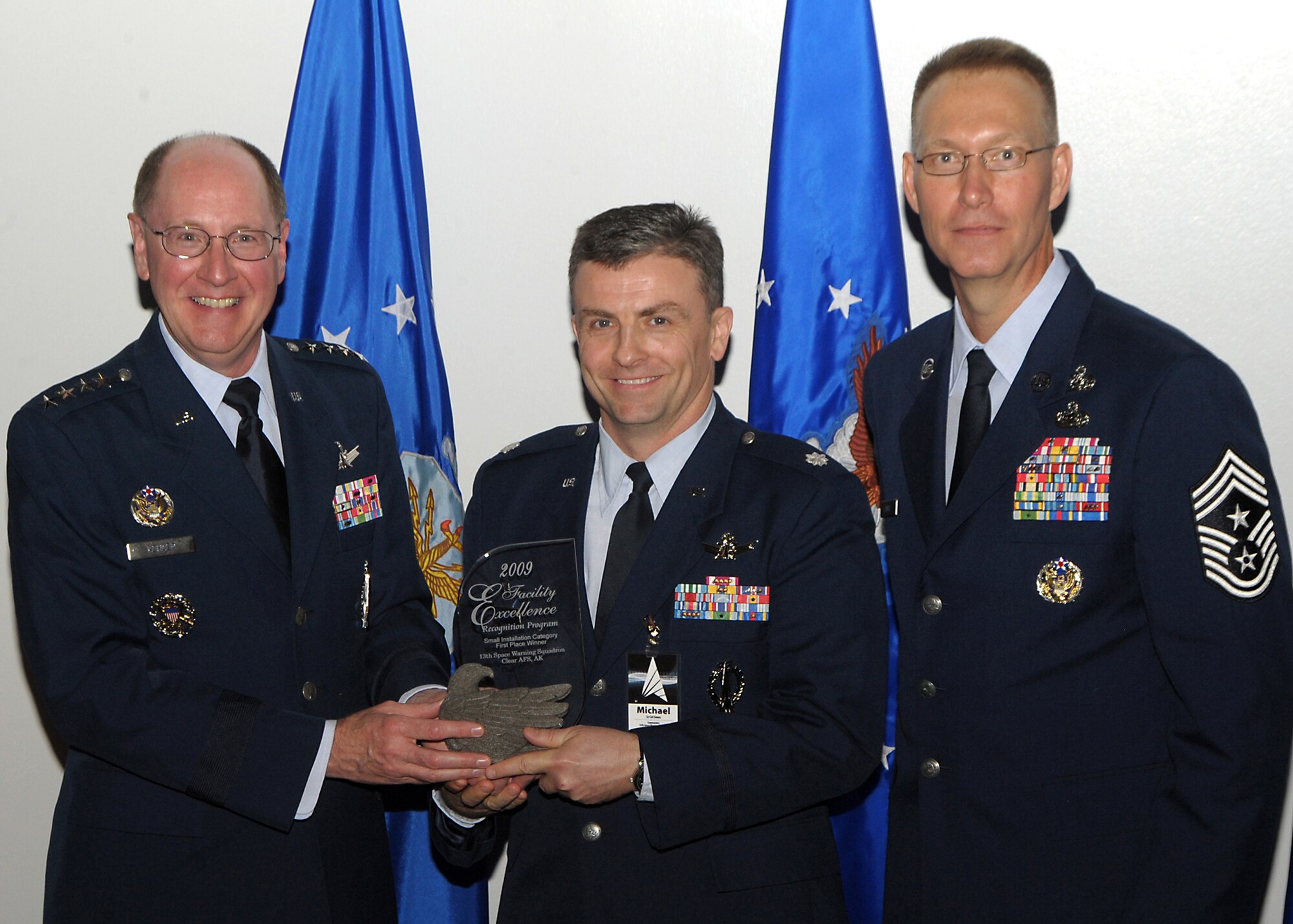 PETERSON AIR FORCE BASE, Colo. -- Gen. C. Robert Kehler, Commander of Air Force Space Command, presents the Major General M.C. "Tim" Padden Facilities Recognition Program Small Installation Award to Lt. Col. Michael Sowa, 13th Space Warning Squadron commander. Also shown is Command Chief Master Sgt. Richard T. Small, AFSPC Command Chief Master Sergeant.  The award was presented during the AFSPC Heritage dinner May 17. (U.S. Air Force photo by Duncan Wood)  