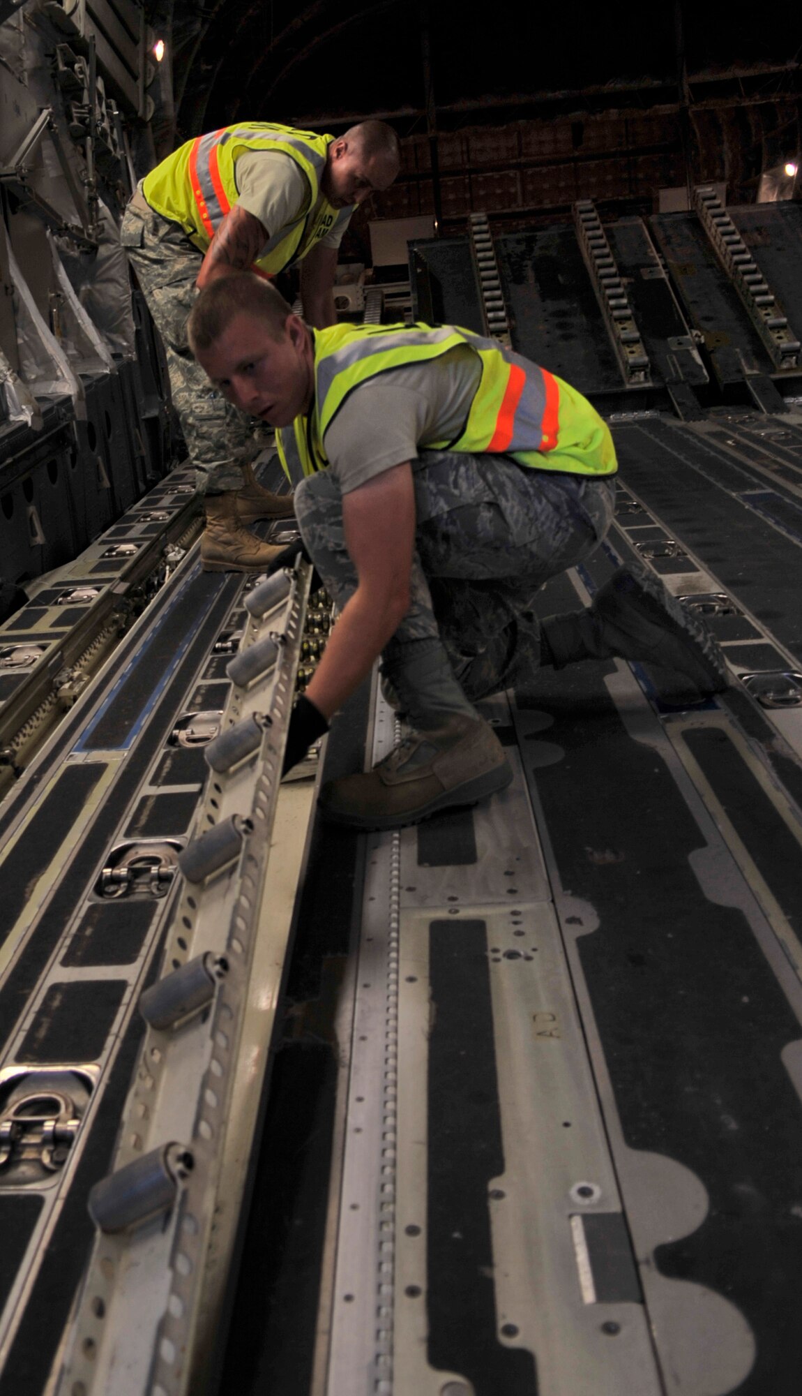 HOLLOMAN AIR FORCE BASE, N.M. -- Staff Sgt. James Stephens and Airman 1st Class Jeffrey Gonzales, 49th Logistics Readiness Squadron, reconfigure the floor of a C-17 Globemaster to accept palletized cargo May 19, 2010. This is the first of several airlift missions taking 49th Fighter Wing assets to Kadena AB, Japan, in support of a U.S. Pacific Command Theater Security Package. ( U.S. Air Force photo by Airman 1st Class Joshua Turner / Released)
