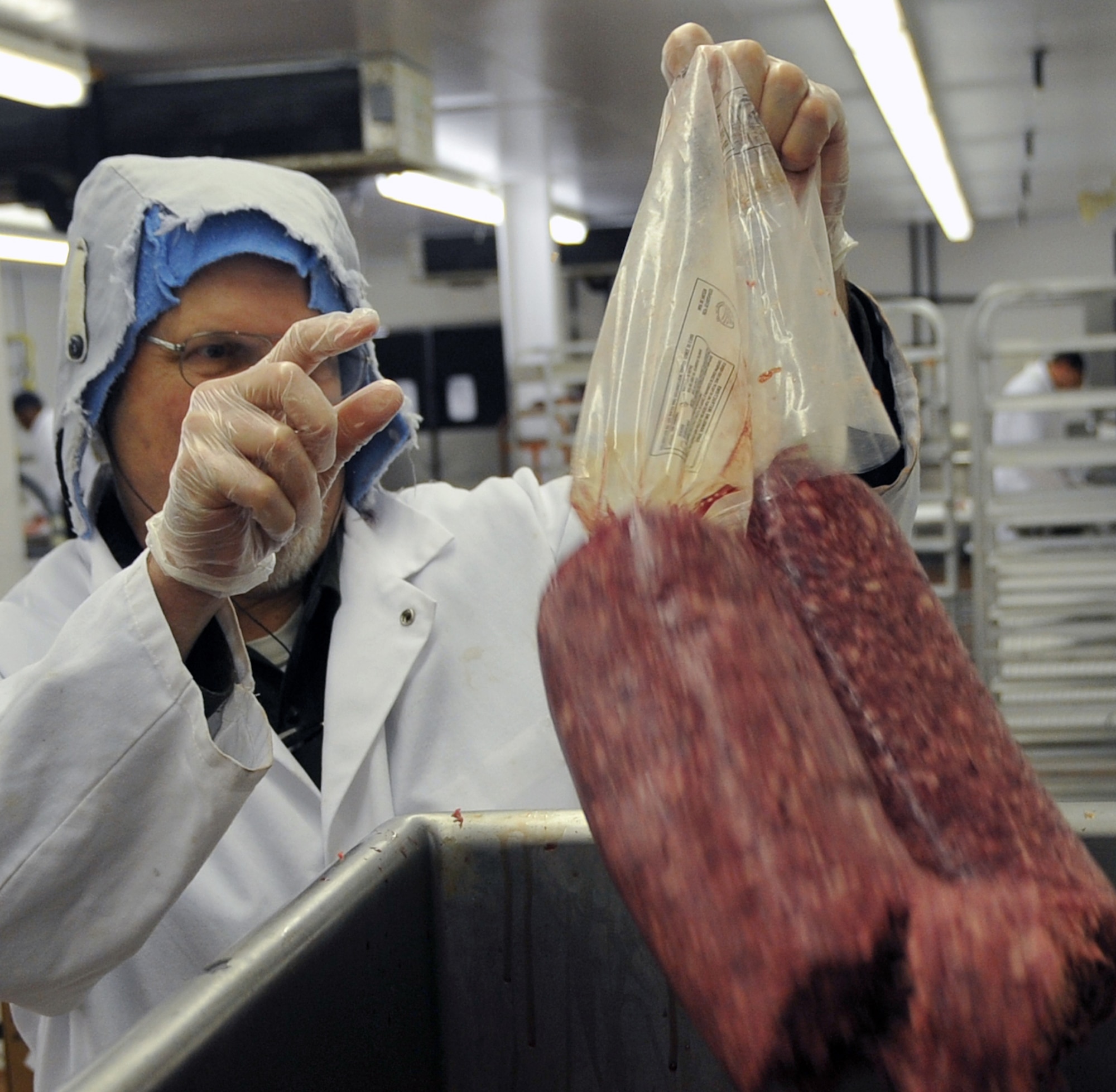 OFFUTT AIR FORCE BASE, Neb. -- Russell Moore, a commissary employee, places ground beef in a machine that prepares it for packaging while working in the Offutt Commissary meat department May 20. The department recently took first place for best in merchandising at the 2nd Annual Defense Commissary Agency Meat Merchandising Contest. U.S. Air Force Photo by Jeff W. Gates