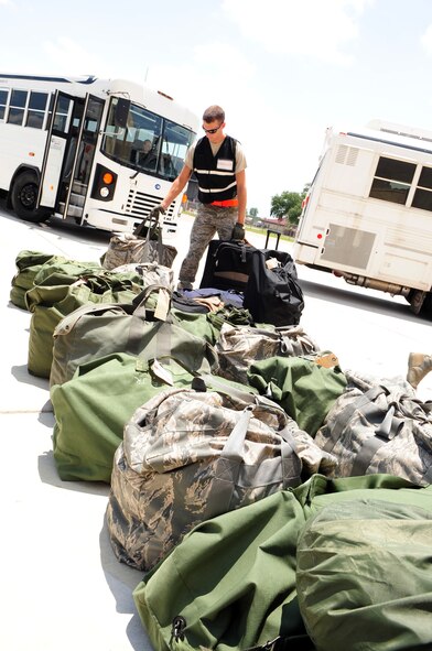 BARKSDALE AIR FORCE BASE, La. – A member of the 2d Logistics Readiness Squadron ready team carries the luggage of Nuclear Operational Readiness Exercise participants as they process through a mock deployment line May 18. The NORE prepares the 2d Bomb Wing for their upcoming Nuclear Operational Readiness Inspection this summer and helps to maintain a state of readiness throughout the wing.  (U.S. Air Force photo by Senior Airman Joanna M. Kresge)