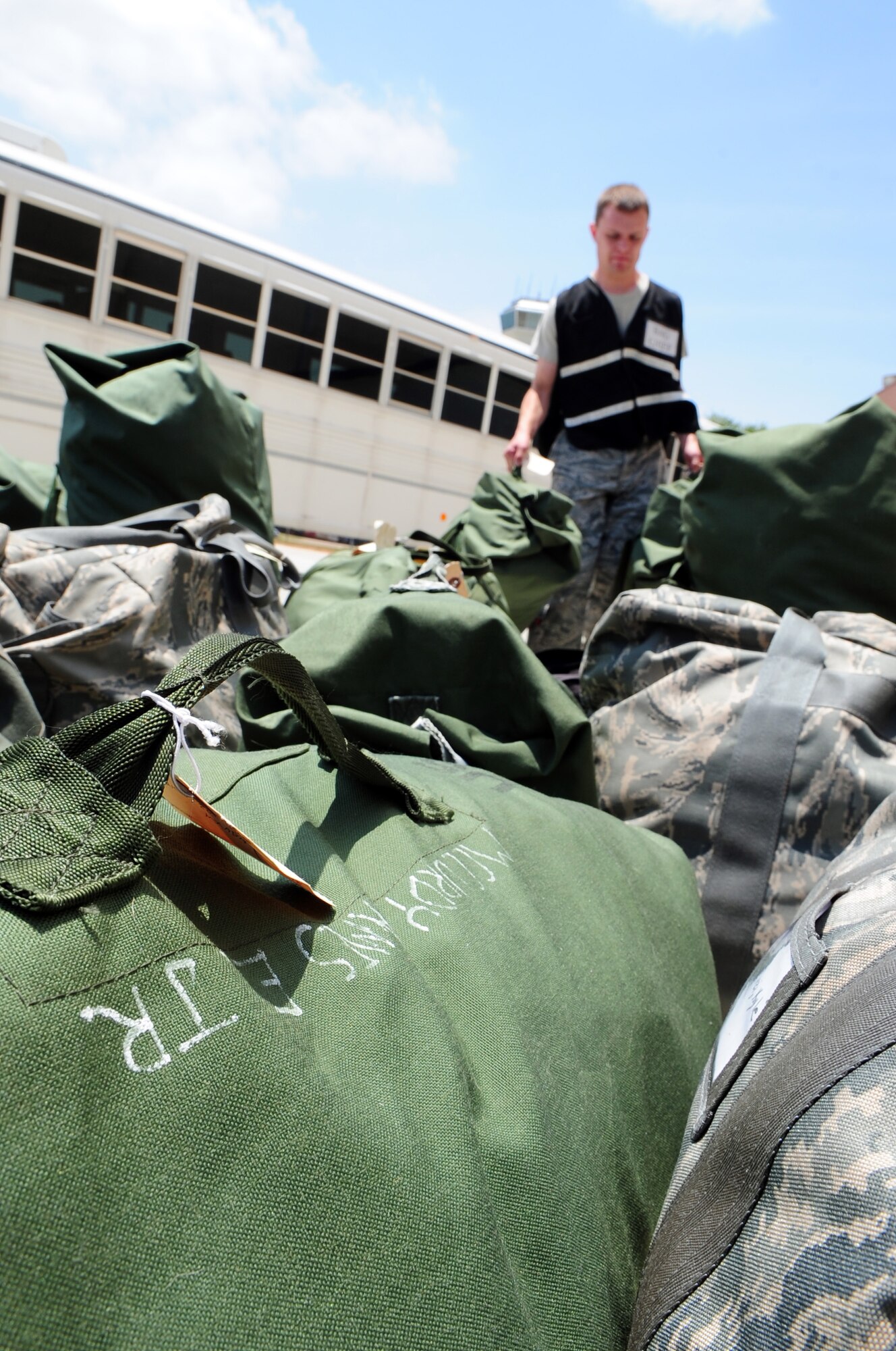 BARKSDALE AIR FORCE BASE, La. – A member of the 2d Logistics Readiness Squadron ready team carries the luggage of Nuclear Operational Readiness Exercise participants as they process through a mock deployment line May 18. The NORE prepares the 2d Bomb Wing for their upcoming Nuclear Operational Readiness Inspection this summer and helps to maintain a state of readiness throughout the wing. (U.S. Air Force photo by Senior Airman Joanna M. Kresge)