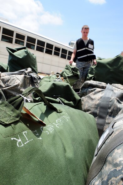 BARKSDALE AIR FORCE BASE, La. – A member of the 2d Logistics Readiness Squadron ready team carries the luggage of Nuclear Operational Readiness Exercise participants as they process through a mock deployment line May 18. The NORE prepares the 2d Bomb Wing for their upcoming Nuclear Operational Readiness Inspection this summer and helps to maintain a state of readiness throughout the wing. (U.S. Air Force photo by Senior Airman Joanna M. Kresge)