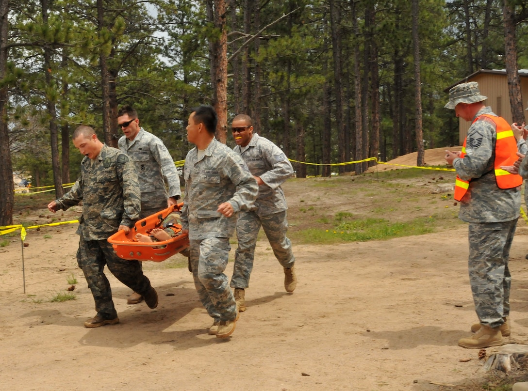 (From left to right) Department of Defense Officer Steven Haymes, Staff Sgt. Alex Andriyanov, Tech. Sgts. Rochanapan Silpe and Leslee Williams cross the finish line carrying a gurney as an official looks on at the Guardian Challenge 2010's obstacle course May 19 during the final portion of the security forces competition. They are members of the Space and Missile Systems Center's 61st Security Forces Squadron team. (Photo by Lou Hernandez)