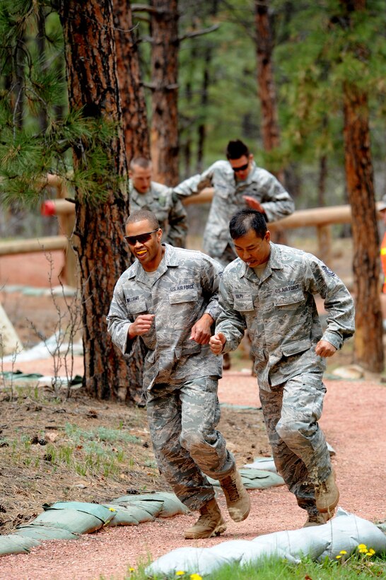 Tech. Sgts. Leslee Williams (left) and Rochanapan Silpe (right) swings proceed onto the next obstacle at the Guardian Challenge 2010's obstacle course May 19 during the final portion of the security forces competition. In the background are Department of Defense Officer Steven Haymes  (left) and Staff Sgt. Alex Andriyanov. All four are members from the Space and Missile Systems Center's 61st Security Forces Squadron. (Photo by Lou Hernandez)