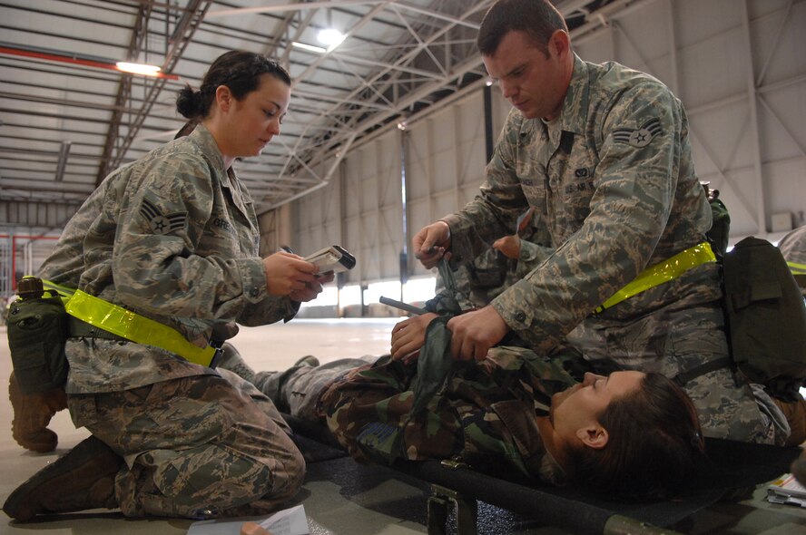 Members of the 86th Airlift Wing provide self-aid and buddy care to a moulage victim during Ability to Survive and Operate training Ramstein Air Base, Germany, May 20. The 86th Airlift Wing Inspections and Readiness flight with the help of augmentees from throughout the base, tested 576 servicemembers in at one of seven stations on M-8/ M-9 chemical detection, self-aid and buddy care and weapons operations procedures in preparation of the upcoming September Operational Readiness Inspection. (U.S. Air Force photo by Tech. Sgt. Michael Voss)
