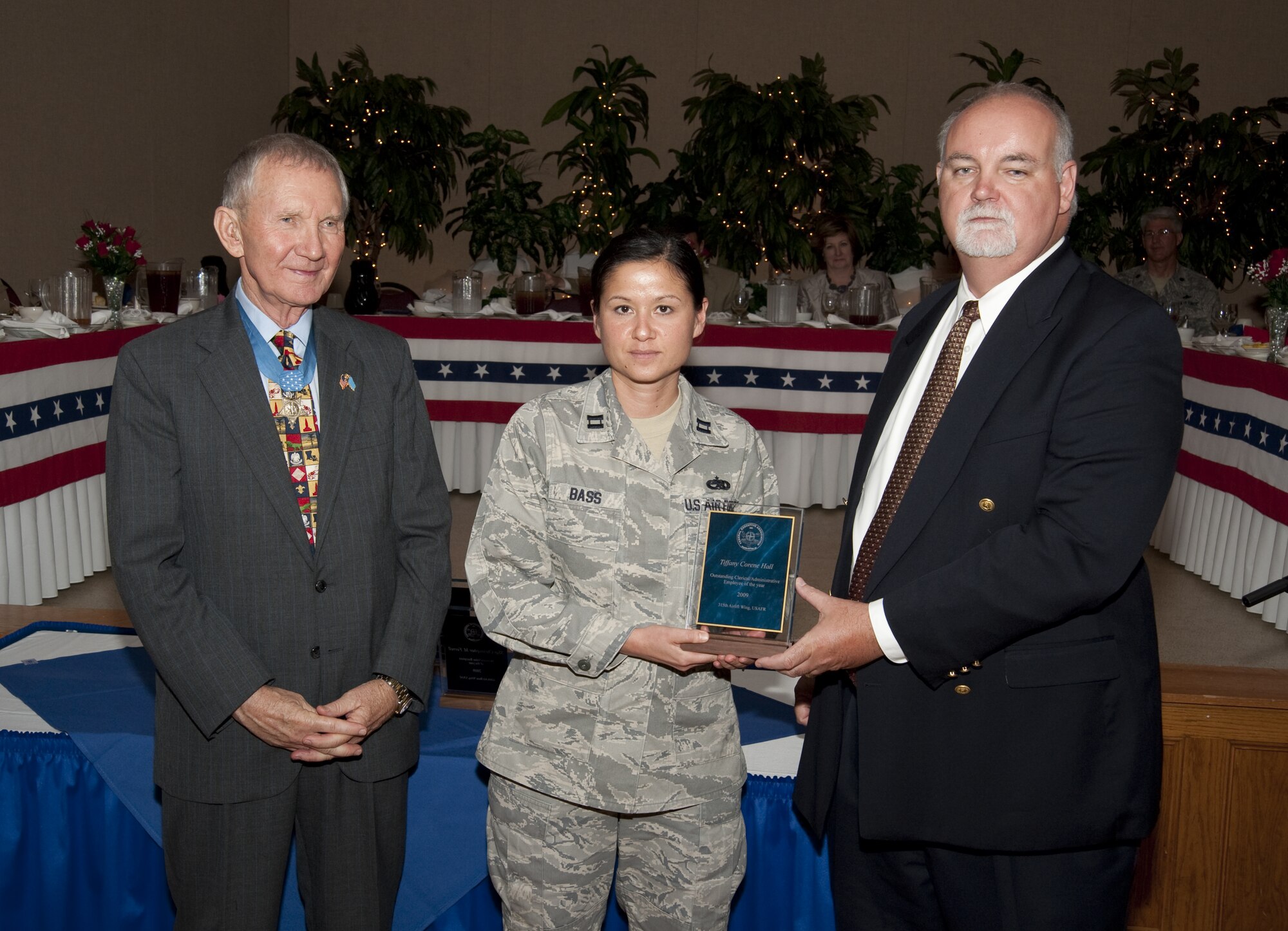 Captain Cynthia Bass, 315th Airlift Wing Charleston Air Force Base S.C. accepts the Outstanding Clerical/Administrative Employee Award on behalf of Tech Sergeant Tiffany Corene Hall, May 19 during the 2010 Federal Employee of the Year Luncheon. Capt. Bass was presented the award by guest speaker and Medal of Honor recipient, Major General James Livingston and co-chairman of the FEA, Tim Shaw. (U.S. Air Force Photo/Joe Bullinger)