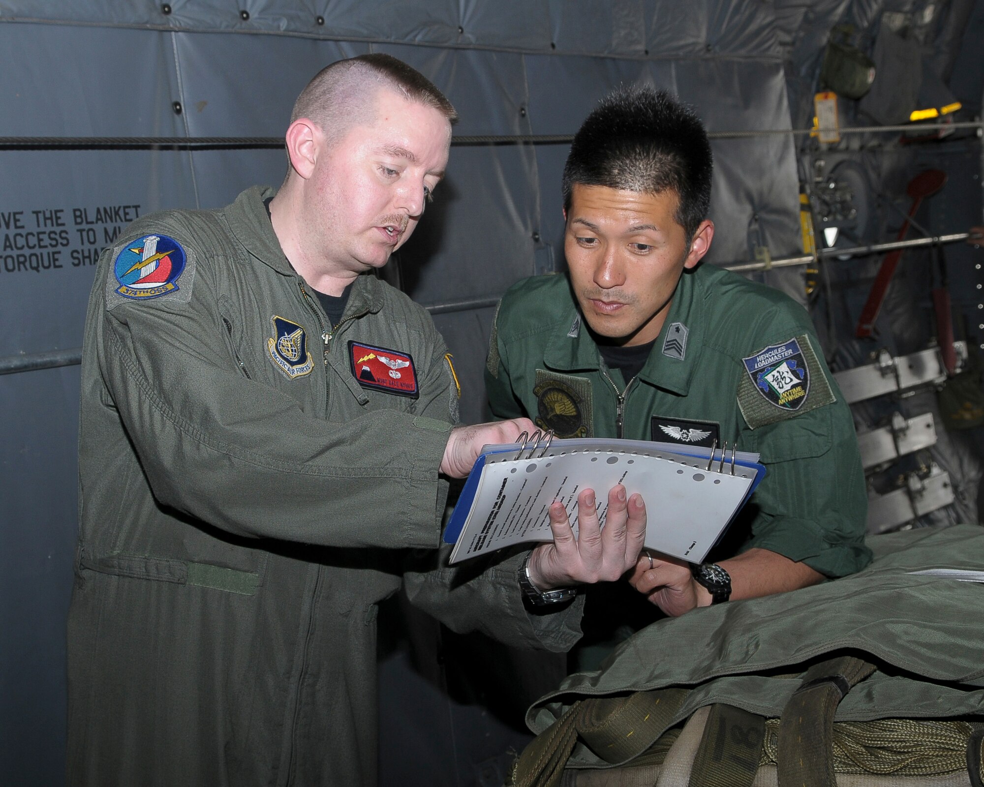 Master Sgt. Dale Nyhus (left) goes through a checklist with Master Sgt. Hioshi Moriyama during Joint Air Delivery Inspection training May 5, 2010, at Yokota Air Base, Japan. Sergeant Nyhus is a 374th Operations Support Squadron joint air delivery inspector and loadmaster. Sergeant Moriyama is a Japan Air Self Defense Force loadmaster. (U.S. Air Force photo/Airman 1st Class Sean Martin)