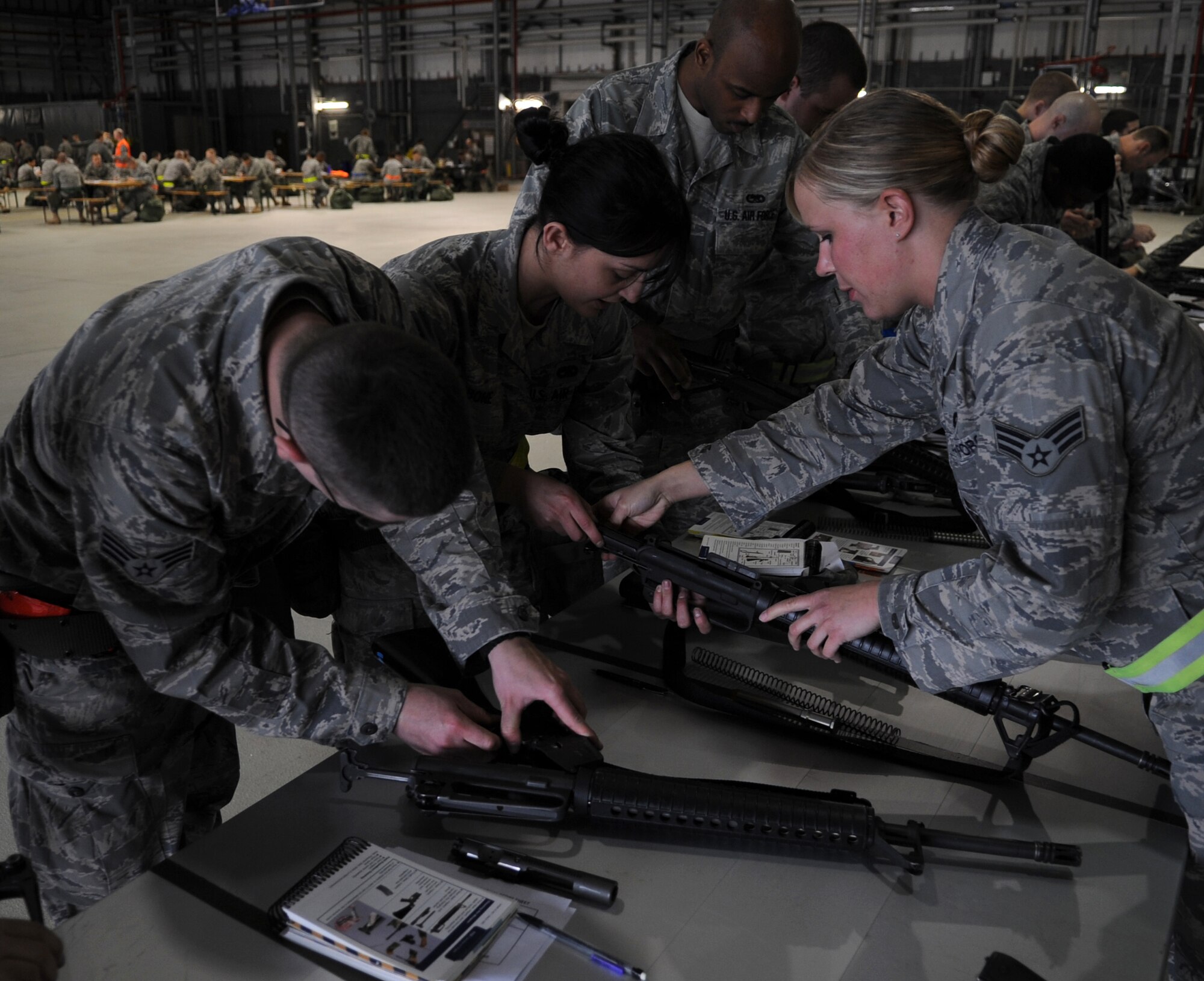U.S. Air Force Senior Airman Jessica Eberhart, 86th Security Forces Squadron, assists an exercise player with disassembling and reassembling an M-16 rifle during an Ability to Survive and Operate (ATSO) exercise, Ramstein Air Base, Germany, May 20, 2010. The wing conducts exercises to evaluate its mission readiness and ability to survive and operate in a chemical environment. (U.S. Air Force photo by Airman 1st Class Caleb Pierce)