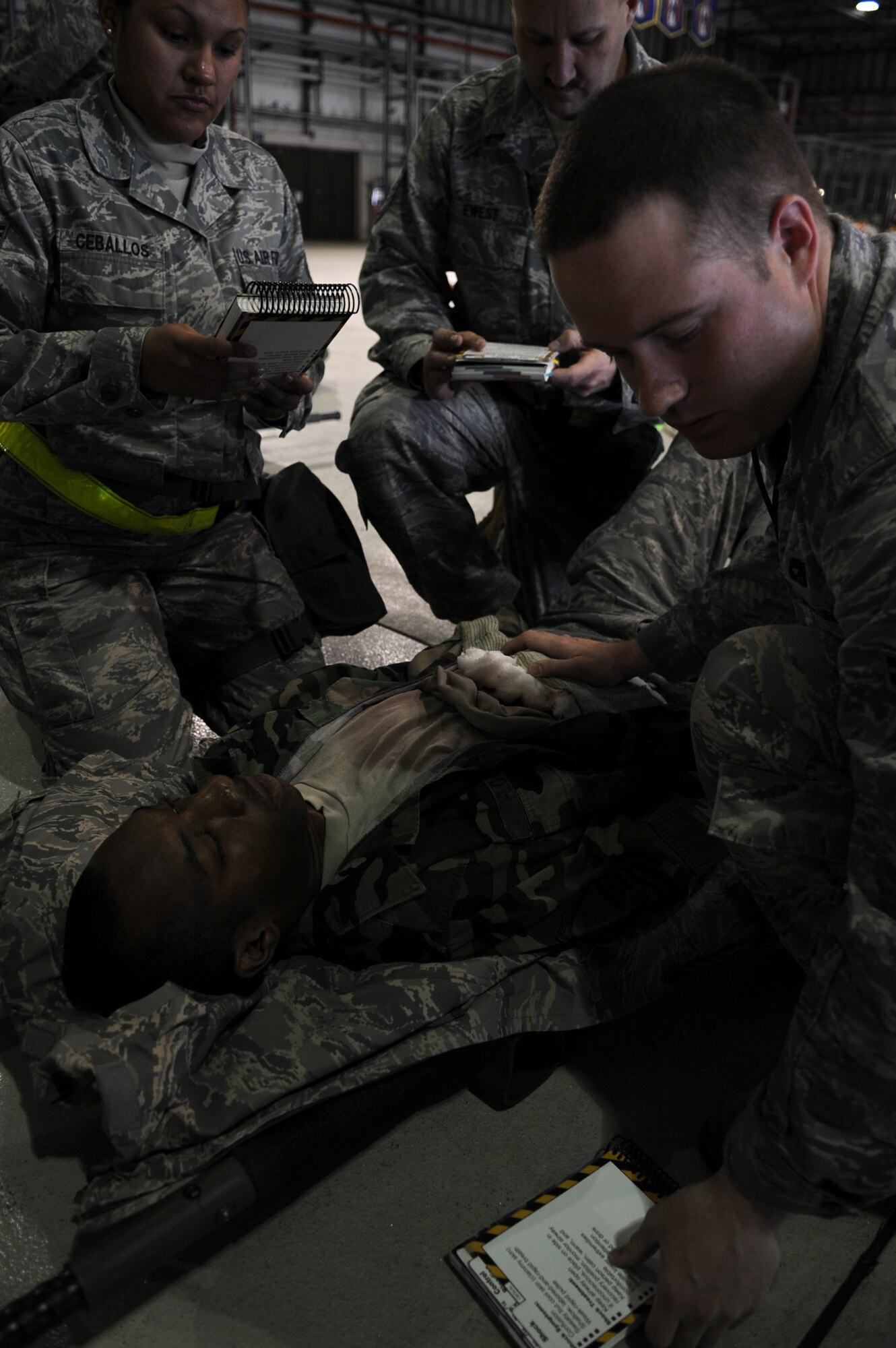 Airmen demonstrate the proper Self Aid Buddy Care methods during an Ability to Survive and Operate (ATSO) exercise, Ramstein Air Base, Germany, May 20, 2010. The wing conducts exercises to evaluate its mission readiness and ability to survive and operate in a chemical environment. (U.S. Air Force photo by Airman 1st Class Caleb Pierce)