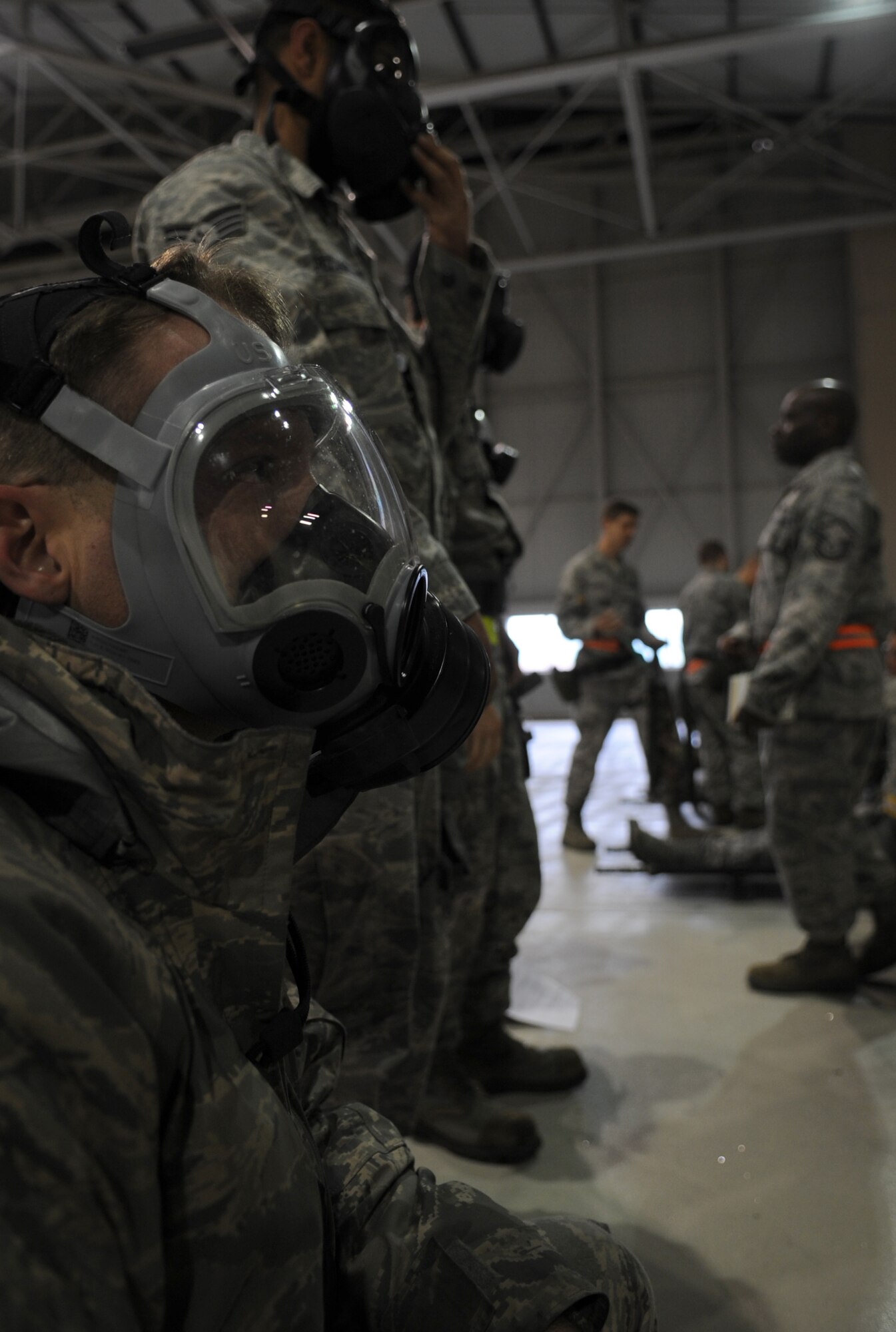 Airmen don gas masks during an Ability to Survive and Operate (ATSO) exercise, Ramstein Air Base, Germany, May 20, 2010. The wing conducts exercises to evaluate its mission readiness and ability to survive and operate in a chemical environment. (U.S. Air Force photo by Airman 1st Class Caleb Pierce) 
