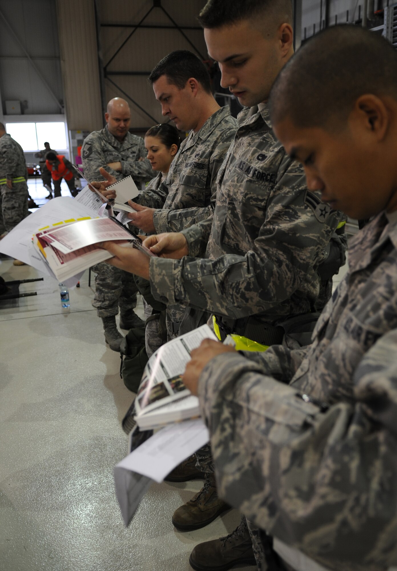Airmen review their Airman's Manual during an Ability to Survive and Operate (ATSO) exercise, Ramstein Air Base, Germany, May 20, 2010. The wing conducts exercises to evaluate its mission readiness and ability to survive and operate in a chemical environment. (U.S. Air Force photo by Airman 1st Class Caleb Pierce)   