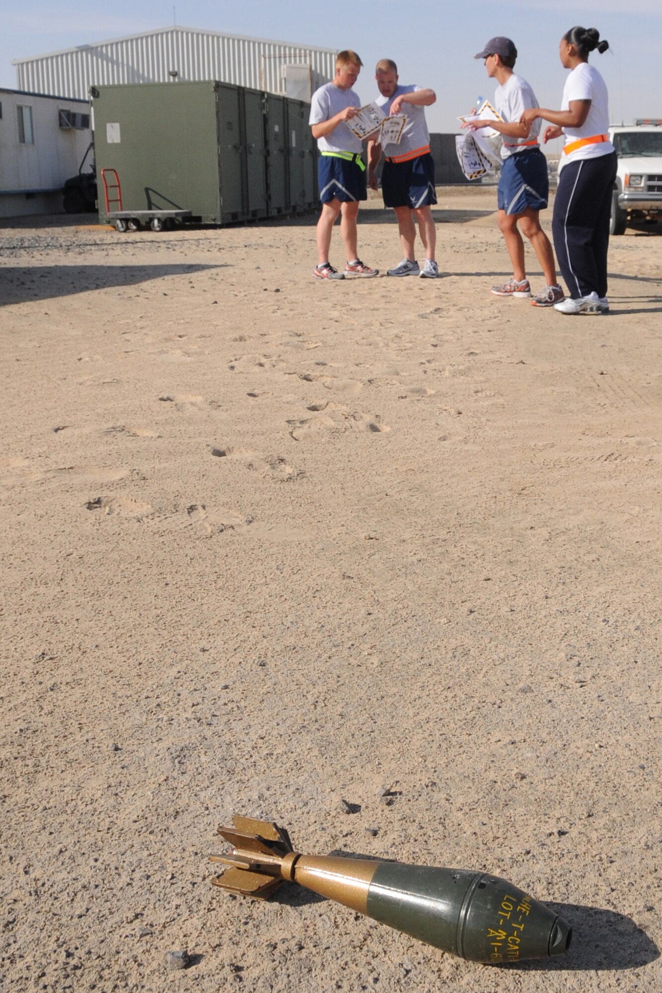 Members of the 380th Air Expeditionary Wing identify an unexploded ordinance, as they compete in the 380th Amazing Race at an undisclosed location in Southwest Asia on May 8, 2010.  Members from across the base competed in various events to win donated prizes. The 380th AEW supports Operations Iraqi Freedom and Enduring Freedom and the Combined Joint Task Force-Horn of Africa. Its comprised of four groups and 12 squadrons and the wing's deployed mission includes air refueling, surveillance and reconnaissance in support of overseas contingency operations in Southwest Asia.(U.S. Air Force photo/Senior Airman Jenifer H. Calhoun/Released)