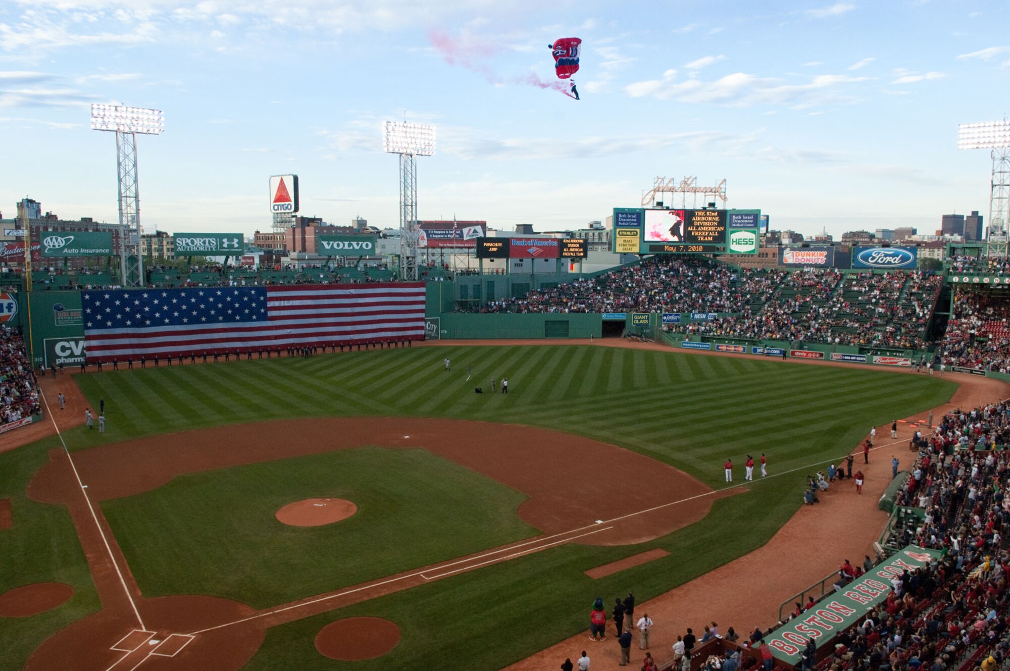 BOSTON – During a recent Red Sox game, Airmen from Hanscom Air Force Base stand in front of the flag as paratroopers from the 82nd Airborne Division, All American Freefall Team, drop in at Fenway Park. (U.S. Air Force photo by Rick Berry)