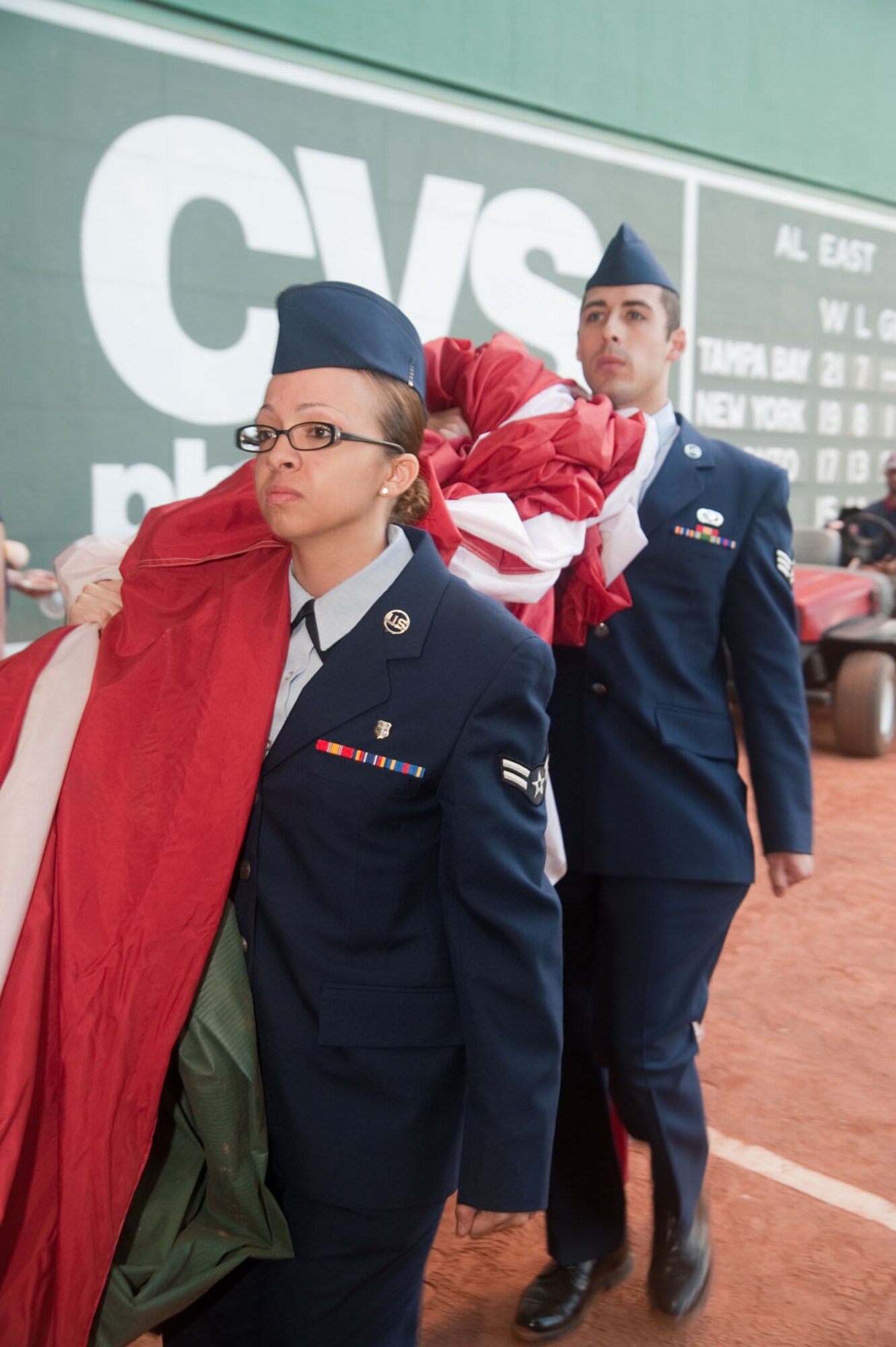 BOSTON - Airman 1st Class Karina Mendoza (left) and Senior Airman Richard Ruiz retrieve the American flag during a recent flag detail during a Red Sox game at Fenway Park. (U.S. Air Force photo by Mark Herlihy)