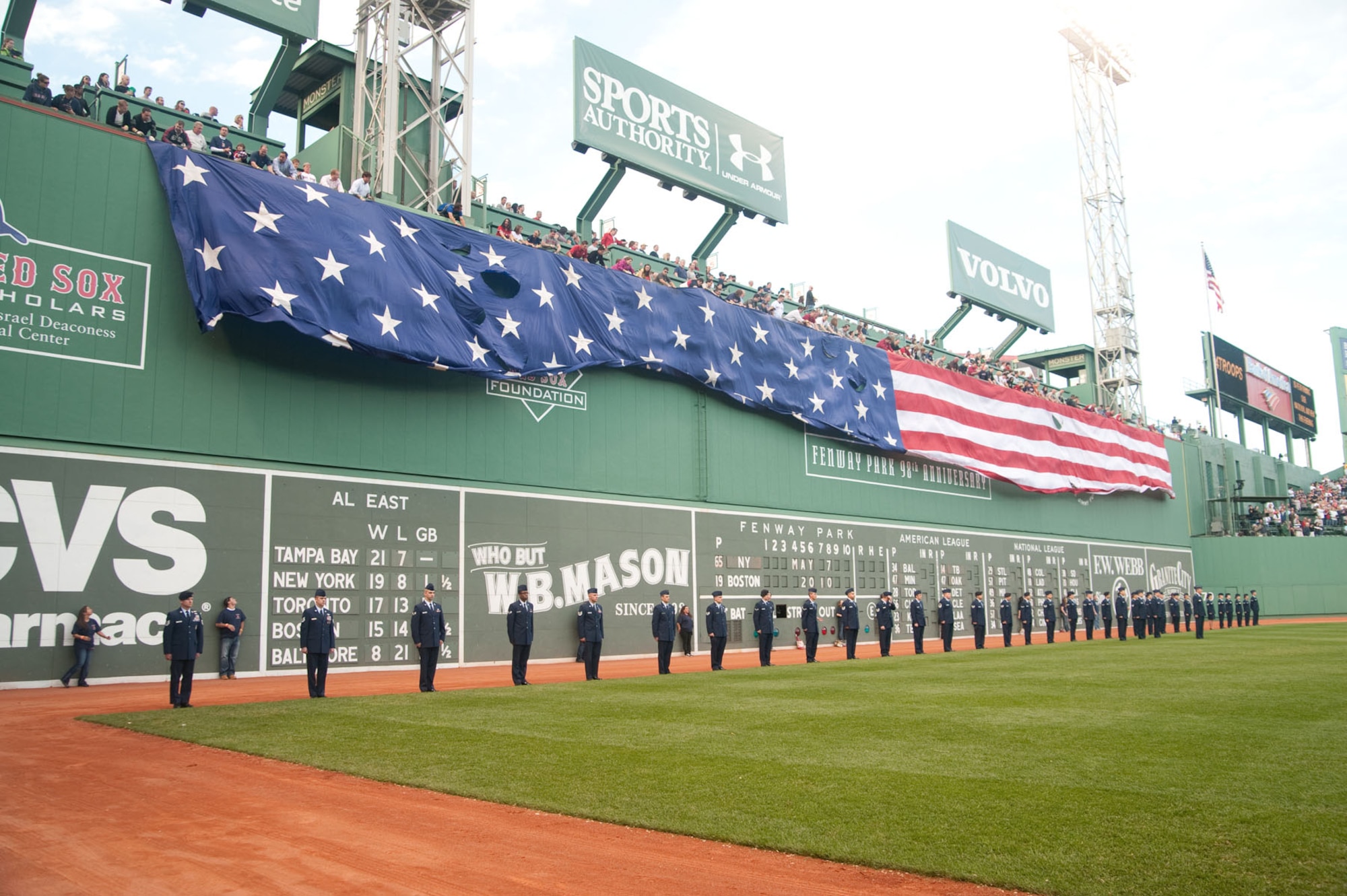 BOSTON – The American flag drops in front of the “green monster” as Airmen from Hanscom Air Force Base stand in front for a flag detail at Fenway Park. (U.S. Air Force photo by Mark Herlihy)