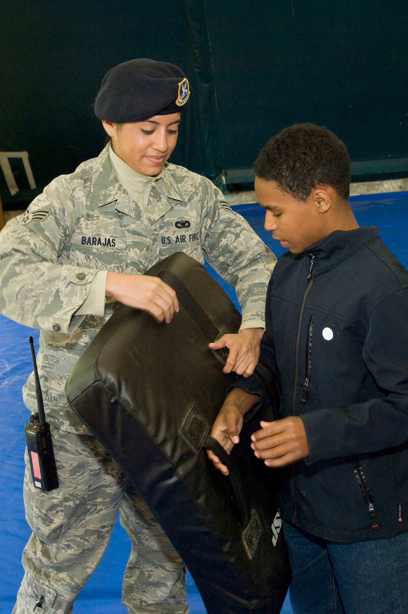 Senior Airman Nicole Brajas explains and demonstrates the baton training pad to Christian Bristow on May 12. The Security Forces Squadron had many items and equipment on display for Exhibition Day as part of Police Week activities. (U.S. Air Force photo by Mark Wyatt) 