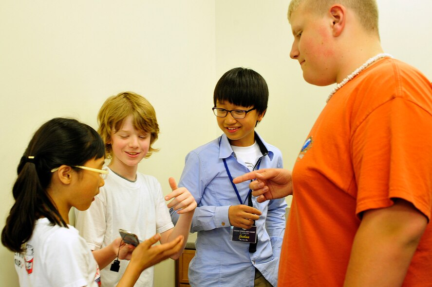 Ji Won Kim, Jordan Robinson, Kun Woo Noh, and Alexander Somers exchange contact information after an English Camp graduation ceremony at Osan Middle School May 20. The graduation recognized 23 Korean Exchange students hosted by U.S. families for three days of educational and cultural immersion. (U.S. Air Force photo/Staff Sgt. Eunique Stevens)