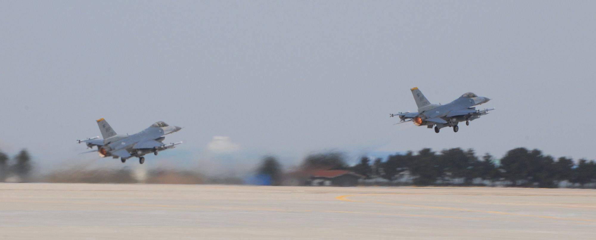 KUNSAN AIR BASE, Republic of Korea--Two F-16 Fighting Falcons from the 80th Fighter Squadron takes off here at Kunsan AB, ROK. The 8th Fighter Wing tested its flying and maintenance operations during surge operations here May 17. The purpose of the surge operation was to test the skills and wartime capabilities of the operators, maintainers and supporting agencies of the Wolf Pack over a 14-hour window and to simulate pilots' wartime flying rates. A successfully generated flight is considered to be a single sortie. (U.S. Air Force photo/Senior Airman Roy Lynch)