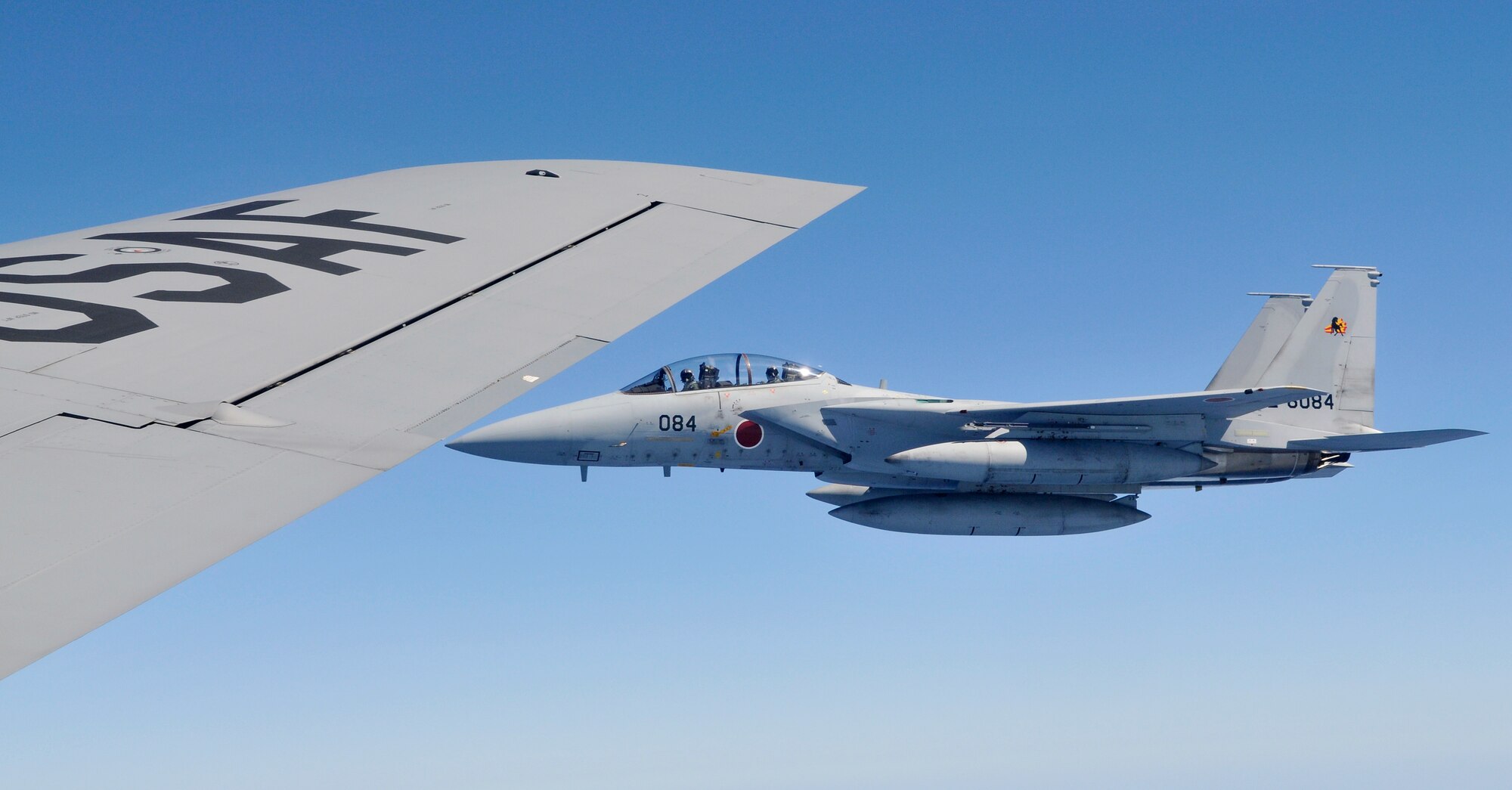 A Japan Air Self Defense Force F-15 waits to refuel just beyond the wingtip of a 909th Air Refueling Squadron KC-135 during bilateral air refueling training May 17. Kadena Airmen have provided air refueling training to JASDF F-15 pilots since 2003. This month, the two nations are working together again to certify about 20 JASDF pilots as they prepare to participate in an upcoming Red Flag exercise in Alaska. (Air Force/Tech. Sgt. Chrissy Best)