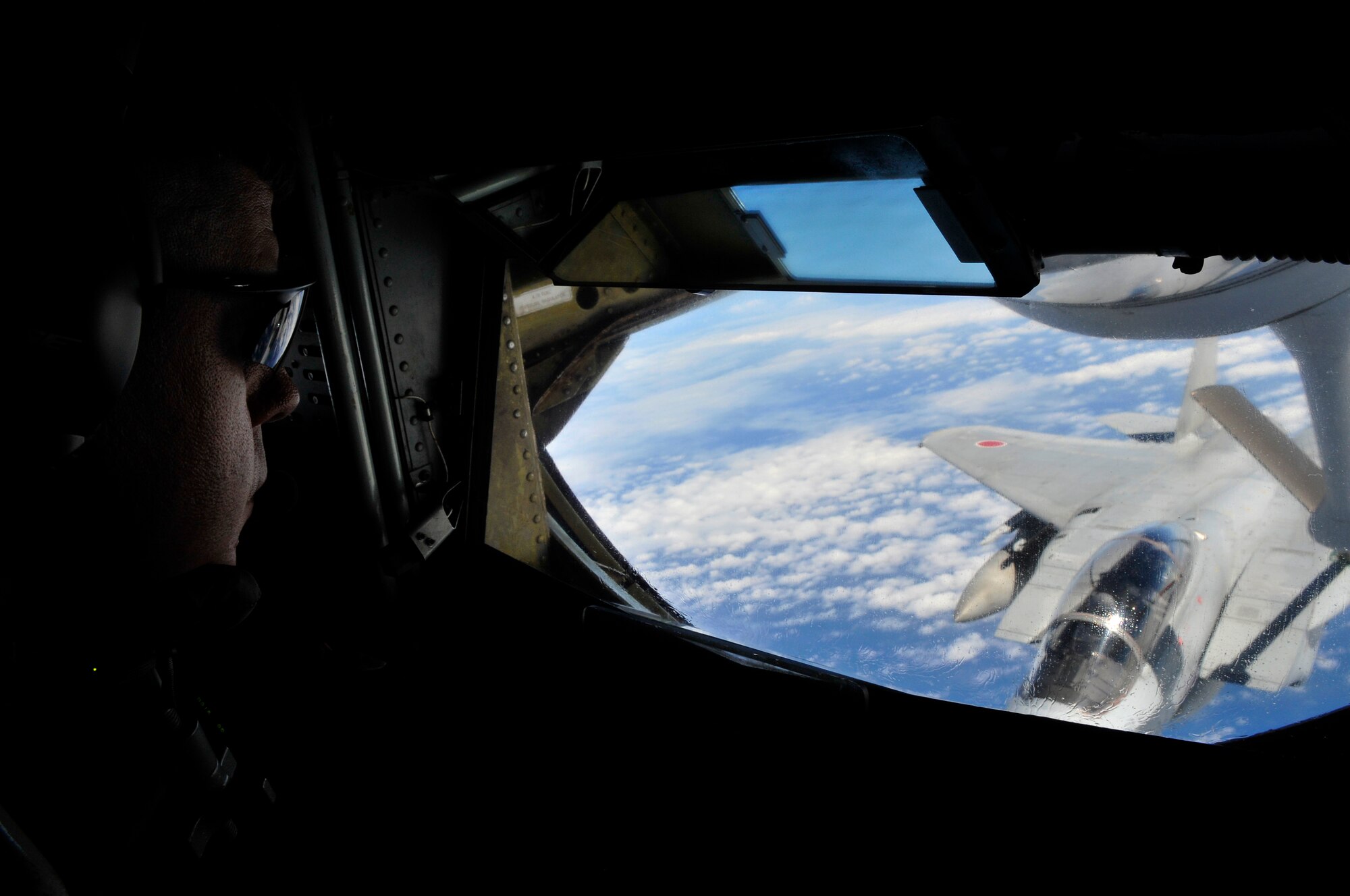 Senior Master Sgt. Michael Steinkraus, 909th Air Refueling Squadron, steers the
refueling boom in the back of a KC-135 Stratotanker offloading fuel to a Japan Air Self Defense Force F-15 during recent bilateral air refueling training May 17. Kadena Airmen have provided air refueling training to JASDF F-15 pilots since 2003. This month, the two nations are working together again to certify about 20 JASDF pilots as they prepare to participate in an upcoming Red Flag exercise in Alaska. (Air Force/Tech Sgt. Chrissy Best)