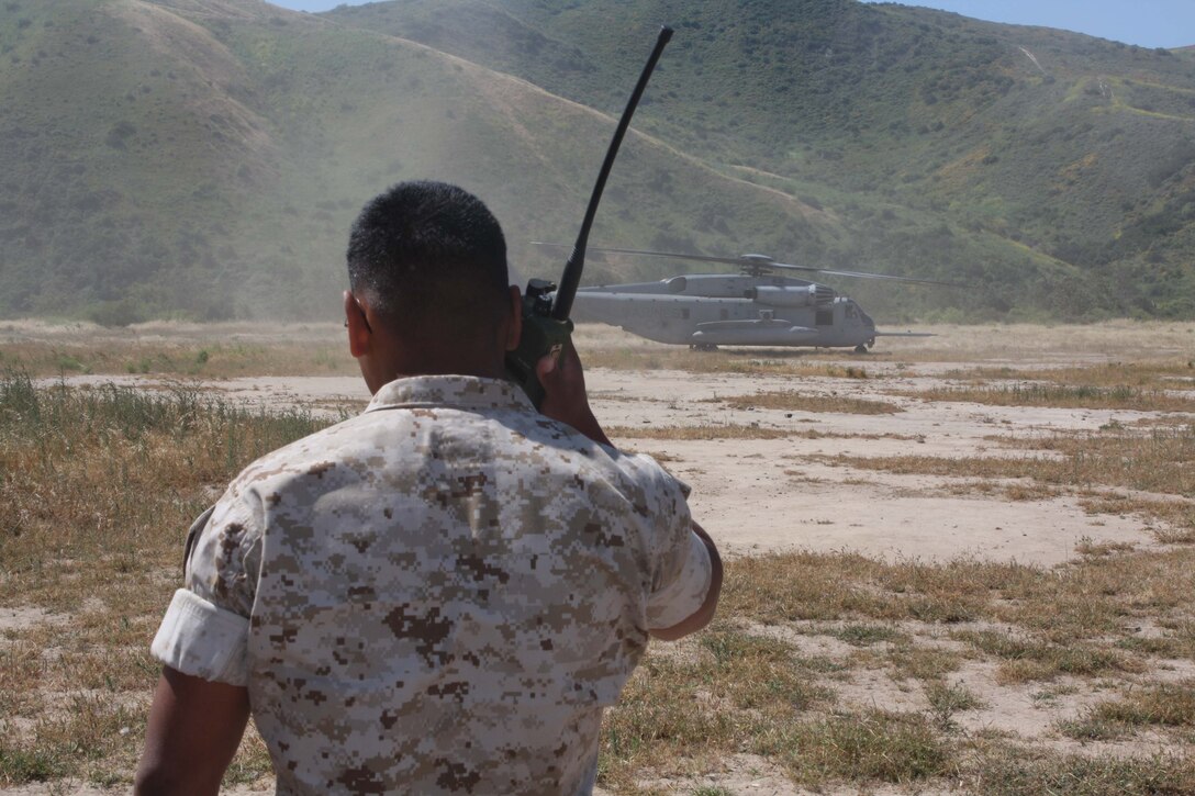 Lance Cpl. John Grady, a company clerk with Headquarters and Service Company, 1st Battalion, 5th Marine Regiment, talks to a pilot from Marine Heavy Helicopter Squadron 462 after successfully guiding the "Super Stallion" into a landing zone.