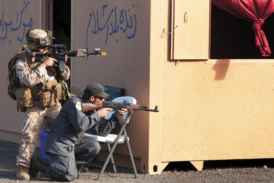 A Marine assigned to Company F, 2nd Battalion, 3rd Marines, and an Afghan National Police role player sight in following an improvised explosive device attack at Marine Corps Training Area Bellows May 20. “DTS #2 is an excellent [counterinsurgency operations] training tool,” Houston said. “It puts Marines in the warrior mindset. Killing the enemy isn’t hard — finding them is. This training helps us find them.”