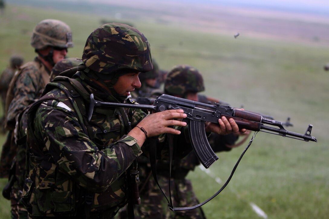 Staff Sgt. Adrian Puricel, a Romanian Marine with Amphibious Company, 307th Battalion, fires at his target during a combat marksmanship exercise with Marines and Sailors with scout platoon, Headquarters and Service Co.,1st Tank Bn., at Babadag Training Area, Romania, May 21. During the exercise, the Romanians and U.S. Marines fired more than 13,000 rounds of ammunition.