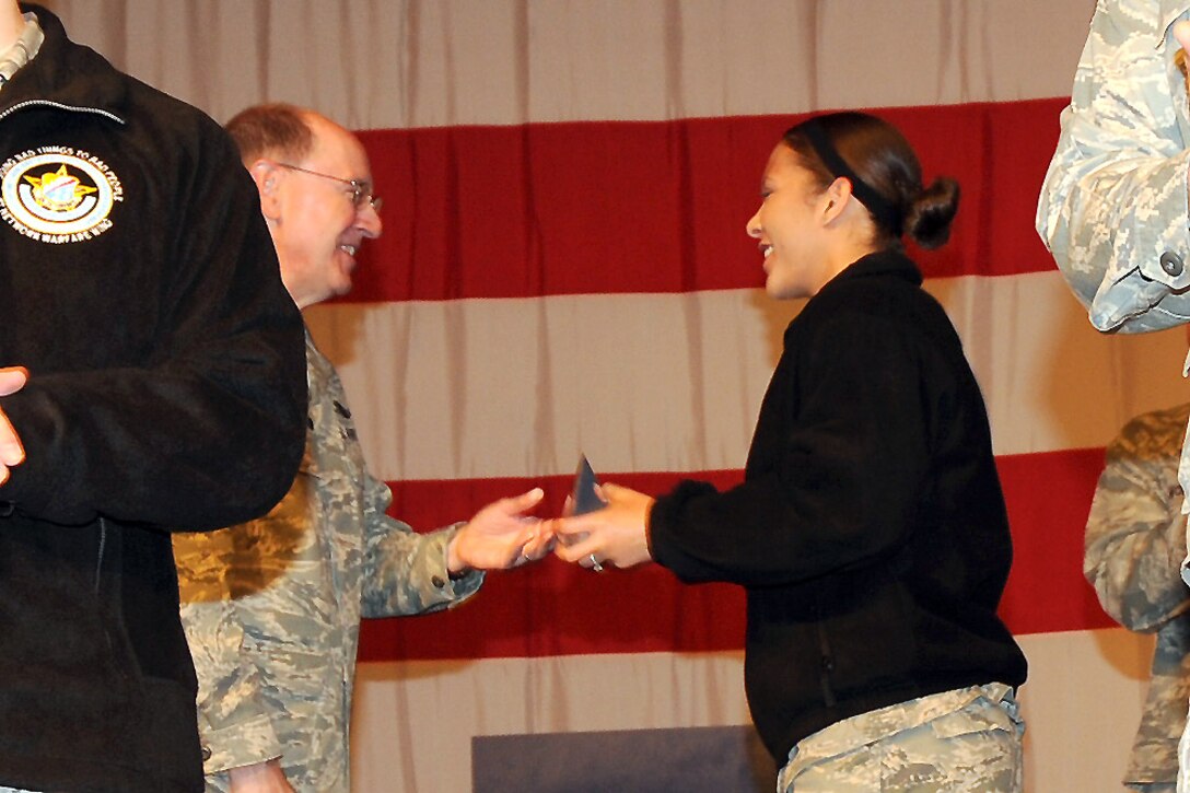 Gen. C. Robert Kehler, Commander of Air Force Space Command presents a memento to 1st Lt. Ashley Housley of the Military Satellite Communications Systems Wing during Guardian Challenge 2010 Opening Ceremony May 21 at Peterson Air Force Base, Colo. Lieutenant Housley is one of the youngest competitors. (Photo by Lou Hernandez)