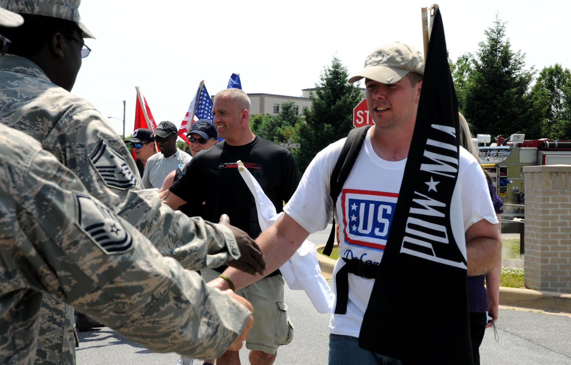 Reservists, active-duty members, guardsmen and civilians who participated in a 47-mile ruck march beginning at the Delaware Air National Guard wing headquarters in New Castle, come to the finish near the base flag pole here. Tech. Sgt. David Jackson, 512th Logistics Readiness Flight, organized the march two years ago to celebrate his college graduation from Wilmington University. (U.S. Air Force photo/Senior Airman Andria J. Allmond)