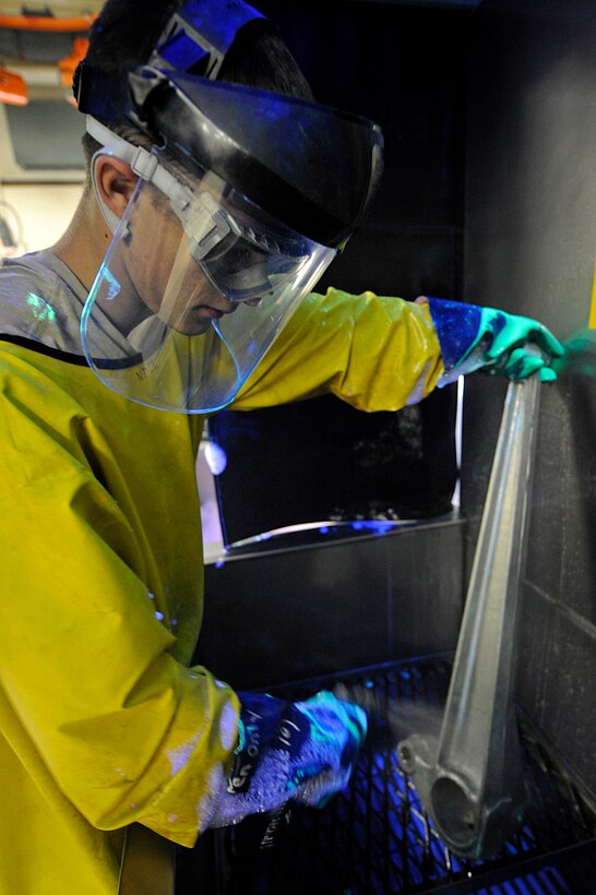 ELLSWORTH AIR FORCE BASE, S.D. -- Airman 1st Class Evan Bryant, 28th Maintenance Squadron non-destructive inspection technician, sprays off a lower link after it was covered in developer, May 20. The developer makes cracks appear brighter during the inspection process. (U.S. Air Force photo/Airman 1st Class Matthew Flynn)