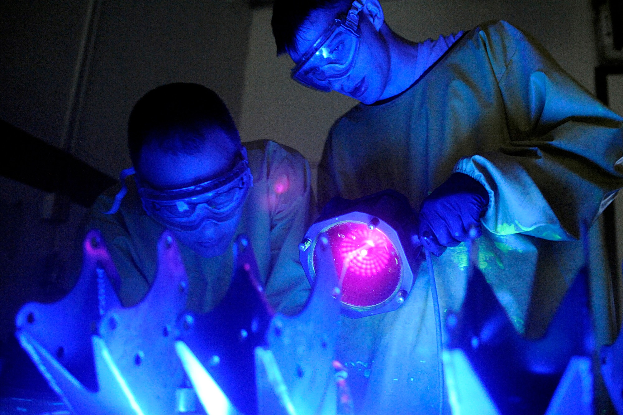 ELLSWORTH AIR FORCE BASE, S.D. -- (Left) Staff Sgt. Ehud Torres and Airman 1st Class Evan Bryant, 28th Maintenance Squadron non-destructive inspection technicians, inspect forward support brackets using an ultraviolet light, May 20. Aircraft maintainers rely on non-destructive inspection technicians to ensure military aviation equipment safety. (U.S. Air Force photo/Airman 1st Class Matthew Flynn)