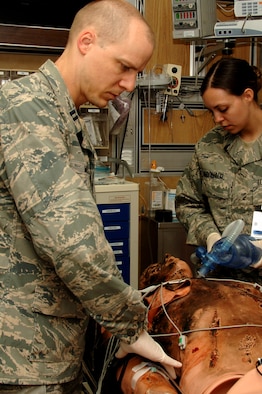 Emergency medicine residents Capt. (Dr.) Tylan Muncy, 59th Surgical Specialties Squadron, and Capt. (Dr.) Carolyn McDonald, 59th Emergency Medicine Squadron, evaluate a burn patient during simulation grand rounds May 21 in the Wilford Hall Medical Center simulation center, Lackland Air Force Base, Texas. The simulation cases can be adapted and created to focus on the needs of a wide range of learners to include paramedics, nurses, medical students and physicians. (U.S. Air Force photo by Senior Airman Nicole Mickle)