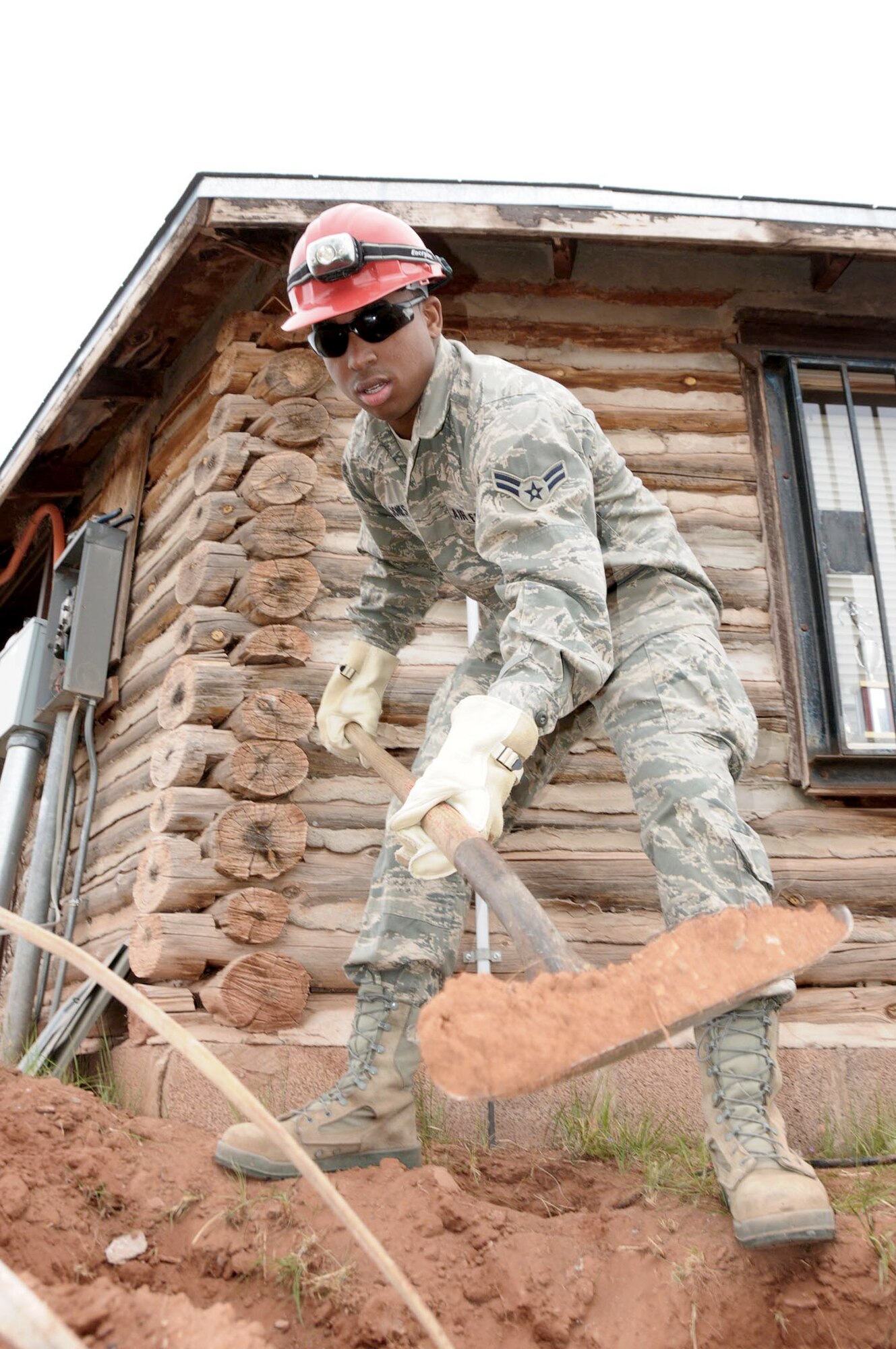 Airman 1st Class Avian Jones digs a trench for a power conduit May 18, 2010, at the St. Michaels Association for Special Education campus in Window Rock, Ariz. Work is being conducted at the SMASE campus as part of the Air Guard's Innovative Readiness Training, a civil-military affairs program linking military units with civilian communities for humanitarian projects. Airman Jones is a member of the Virginia Air National Guard's 203rd Red Horse Squadron. (U.S. Air Force photo/Master Sgt. Jerry Bynum)