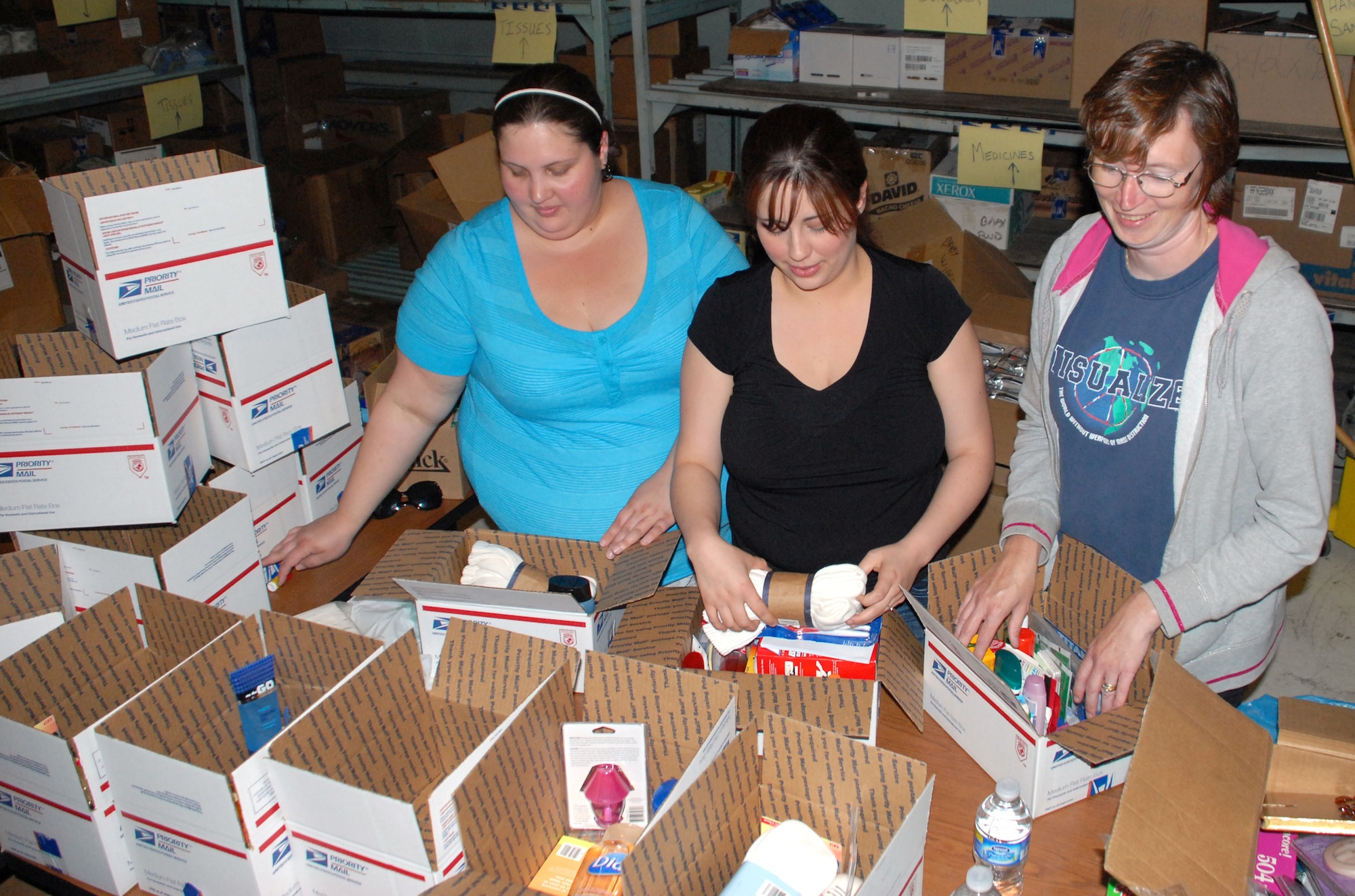 (Left to right) Military spouses Brandy Coble, Amber Reese and Julie Lynn, help to make care packages for deployed Dover Airmen in the United Service Organizations? warehouse at Dover Air Force Base. (U.S. Air Force photo/Airman 1st Class Shen-Chia Chu)