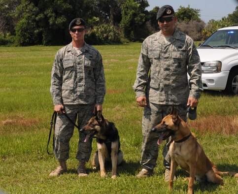 Staff Sgt. Jonathan Desmond (left) and Staff Sgt. Ian Spivey, dog handlers with the 6th Security Forces Squadron Military Working Dogs section, stand with Dena and Rex, two of the squadron’s explosives-detecting canines after a training demonstration at MacDill Air Force Base, Fla. May 21, 2010. The 6th SFS/MWD section has nine explosives-detecting dogs and two narcotics-detecting dogs. (U.S. Air Force photo by Senior Airman Anna-Marie Wyant)
