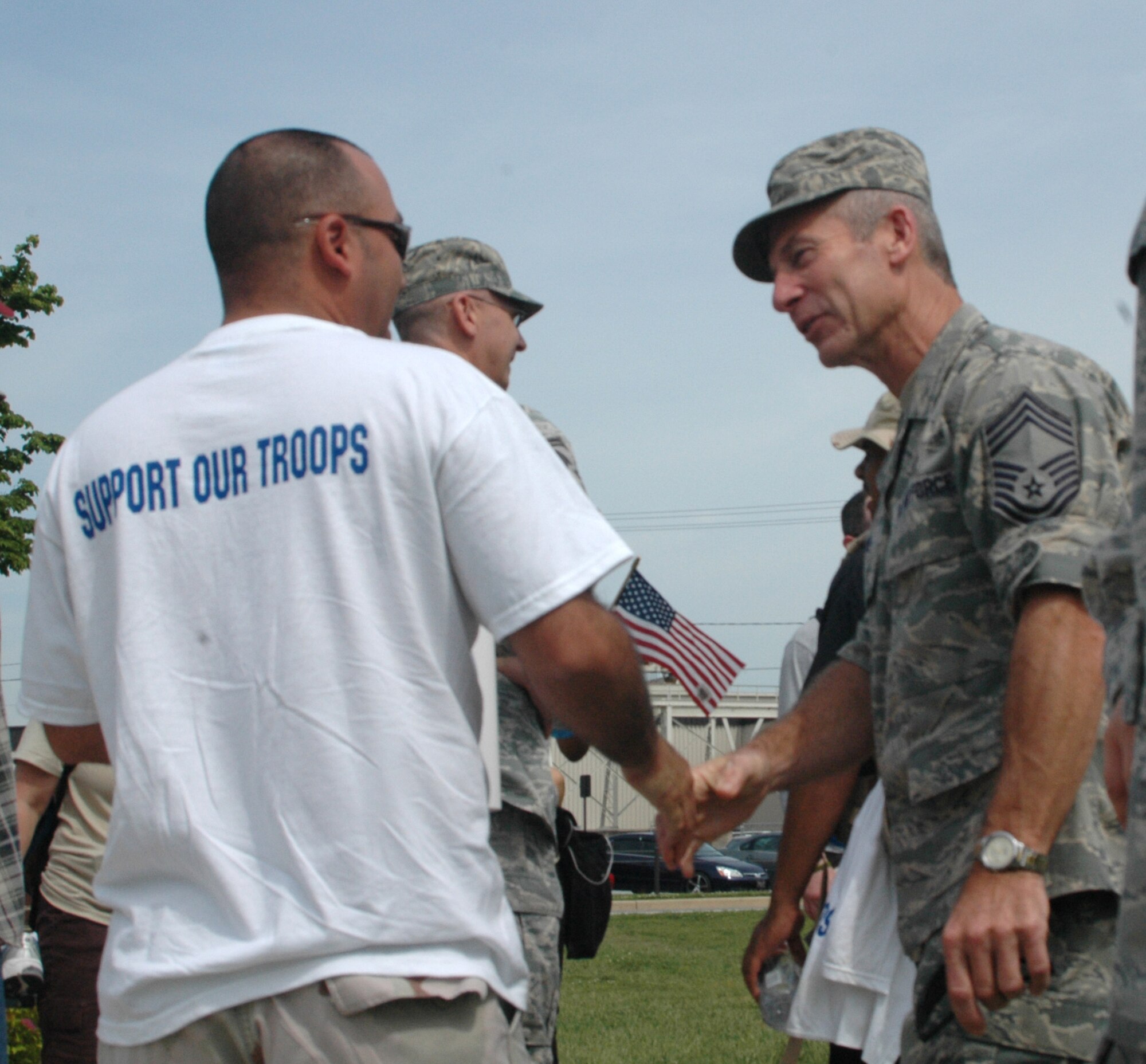 DOVER AIR FORCE BASE, Del.- Chief Master Sgt. Christopher Ford (right), 512th Maintenance Squadron, congratulates Tech. Sgt. Alfonso Torres, 436th Maintenance Squadron, for his participation in the 3rd Annual Base 2 Base March, May 20-21. The march is a 47-mile walk from the Delaware Air National Guard Base in New Castle to the base flag pole here. The purpose of the march is to raise funds for the United Service Organizations Delaware and show support for the sacrifices deployed servicemembers make on a daily basis. Due to work requirements, Chief Ford walked the first eight miles of the march. He continued his support by monitoring the safety and well being of the marchers who finished the trek. (U.S. Air Force photo/Master Sgt. Jake Chappelle)