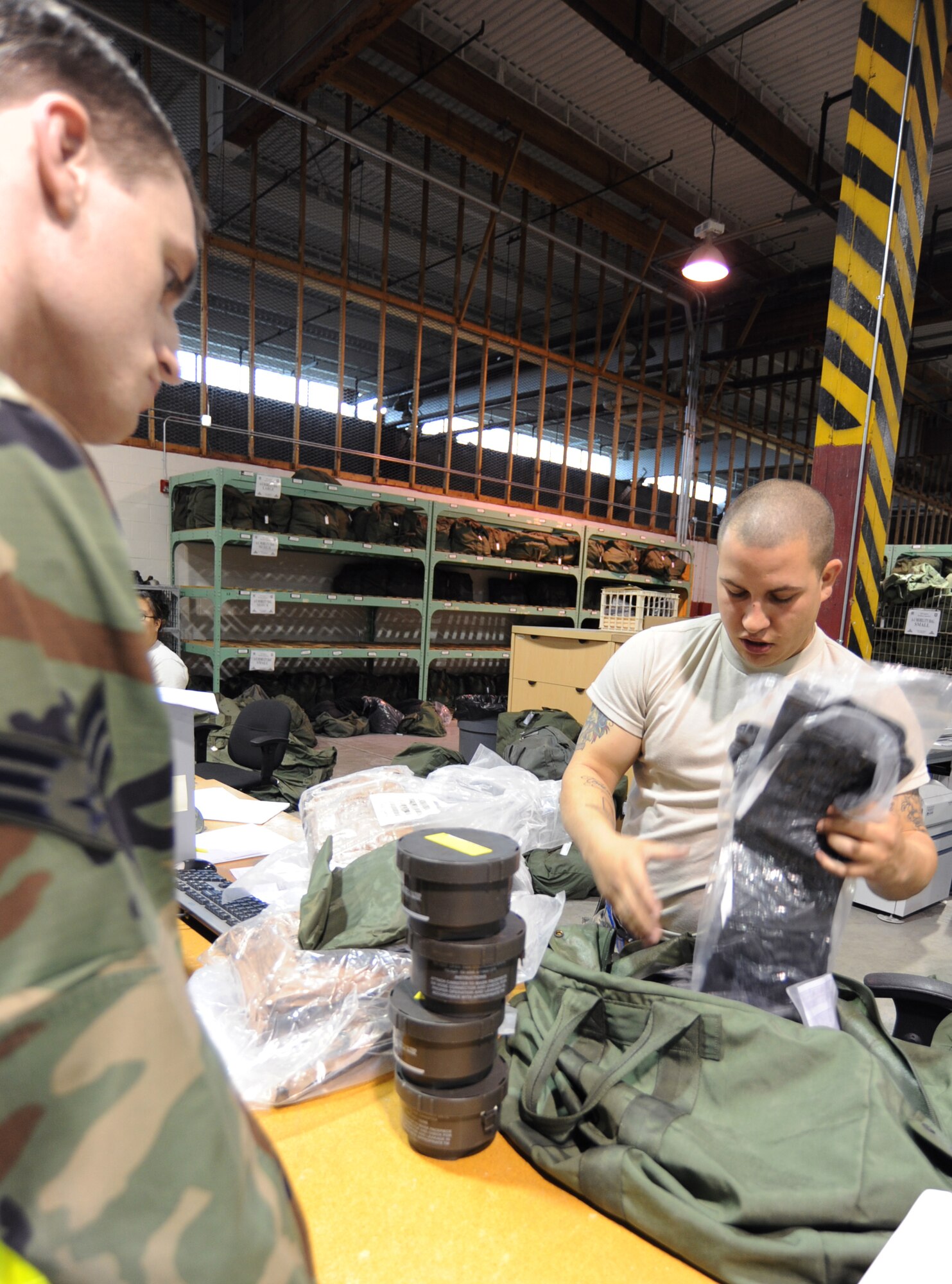 Airman 1st Class Kyle Williams, 22nd Logistics Readiness Squadron individual protective equipment technician, prepares a chemical warfare bag for Senior Airman Greyson Thompson, 22nd Medical Operational Operations Squadron education and training technician, during an operational readiness exercise May 19, 2010, McConnell Air Force Base, Kan.  The inspection of all bag items of deploying Airmen assures they have mandatory items issued to them. The 22nd LRS processed approximately 200 Team McConnell Airmen. (U.S. Air Force photo/Senior Airman Maria Ruiz)