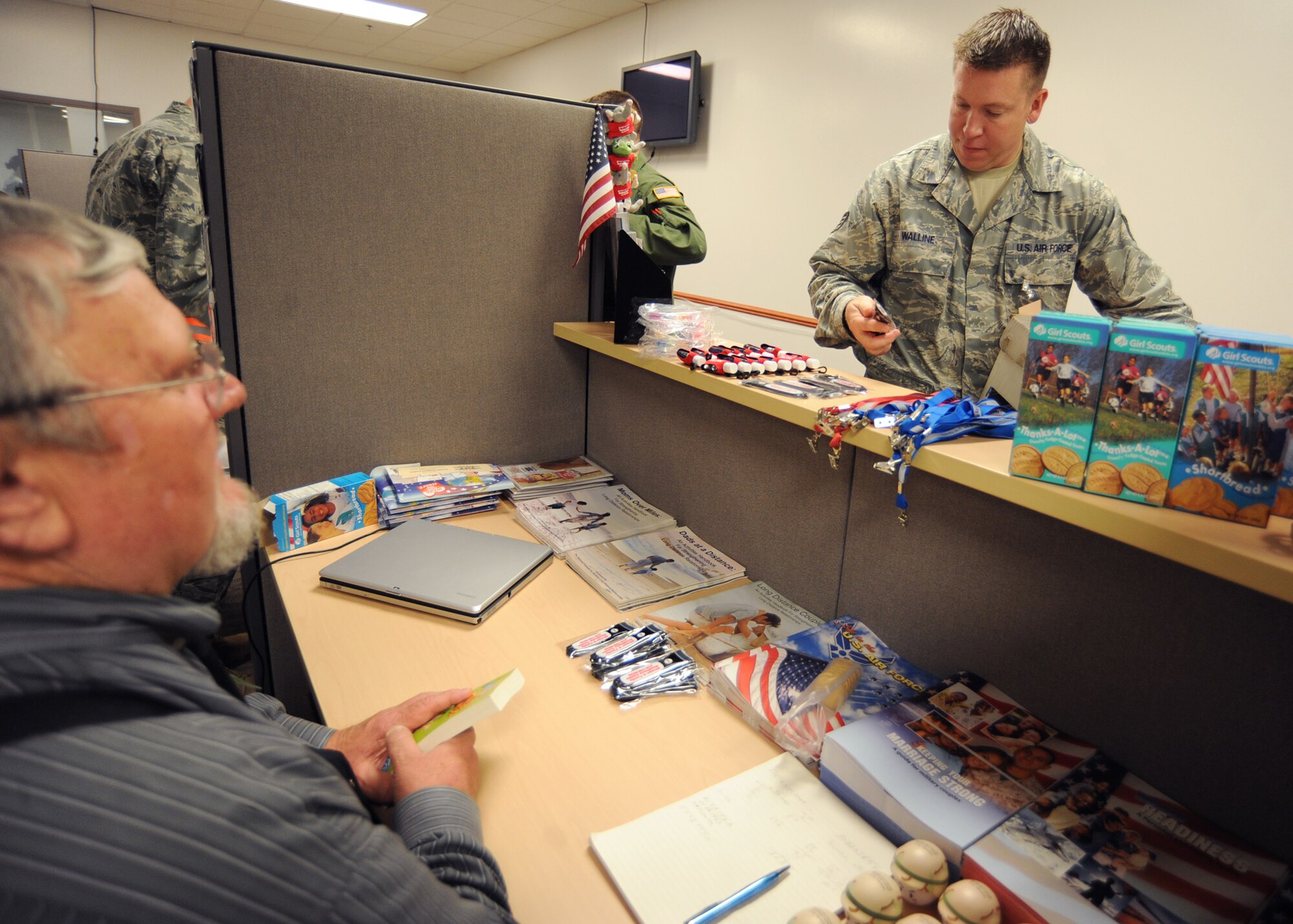 Staff Sgt. Shannon Walline, 22nd Logistics Readiness Squadron fuels technician, grabs a miniature flashlight from the Airmen and Family Readiness Center pre-deployment station during an operational readiness exercise May 19, 2010, McConnell Air Force Base, Kan. Bill Luzier, 22nd Force Support Squadron community readiness consultant, offers different AFRC programs, deployment guides and family assistance information for Airmen processing for “deployment”. The ORE prepared Team McConnell Airmen to deploy as a wing with little notice. (U.S. Air Force photo/Senior Airman Maria Ruiz)