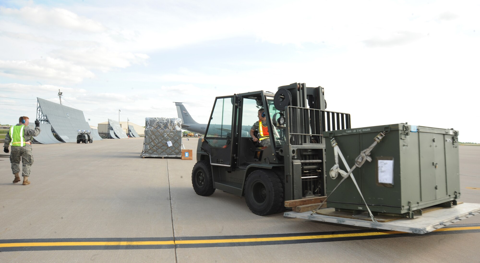 Senior Airman Walter Benson, 22nd Communications Squadron radio maintenance technician, guides a forklift driven by Airman 1st Class Bruno Ruiz Camacho, 22nd Logistics Readiness Squadron flight service center apprentice, during an operational readiness exercise May 18, 2010, McConnell Air Force Base, Kan.  A total of 187 short tons of cargo and 16 groups of Team McConnell Airmen participated in the pre-deployment exercise which analyzed the ability of the wing to generate cargo and personnel for a short notice deployment. (U.S. Air Force photo/Senior Airman Maria Ruiz)