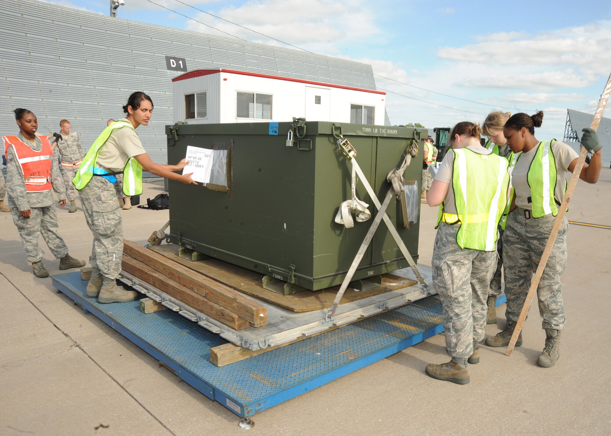Team McConnell Airmen working as in-checkers for the cargo deployment function area inspect a cargo bin for loading onto an aircraft during an operational readiness exercise May 18, 2010, McConnell Air Force Base, Kan. The inspection requires the Airmen to accurately annotate the weight and size measurement of cargo bins, while also properly packaging hazardous materials. Cargo bins unfit for loading can harm the aircraft and endanger passengers by un-stabilizing the weight onboard or releasing any hazardous materials. (U.S. Air Force photo/Senior Airman Maria Ruiz) 