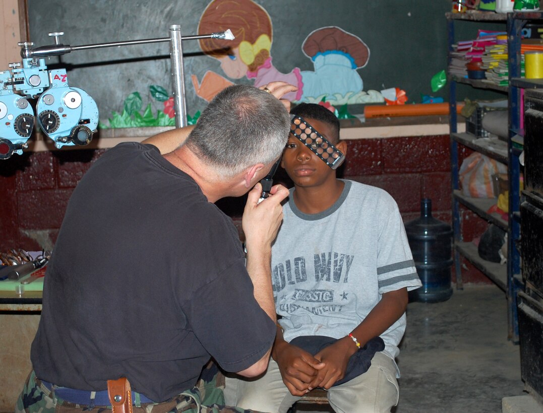 Lt. Col. Ed Tuhy, 173rd Medical Group Optometrist, examines a patient in Puerto Barrios, Guatemala during the Beyond Horizon's exercise April 12, 2010.  Twenty three personnel from the 173rd MDG deployed to Guatemala in support of this exercise which is designed to bring basic medical, dental and optical care to communities in need.   (U.S. Air Force Photo by Unknown)