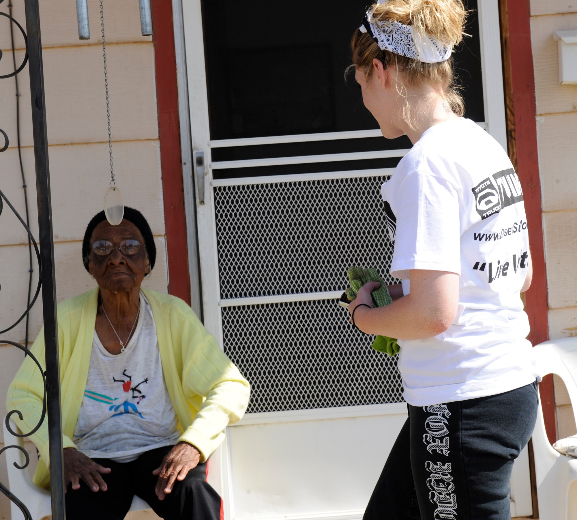 ALAMOGORDO, N.M. -- Airman 1st Class Sondra Escutia, from the 49th Fighter Wing at Holloman Air Force Base, speaks with Elma Smith, an Alamogordo resident, after helping clean her yard during the United Way Day of Caring May 14, 2010. More than 400 members of Team Holloman turned out to help beautify the cities of Alamogordo, Tularosa and Cloudcroft during the annual volunteer event. (U.S. Air Force photo by Airman 1st Class Eileen Payne / Released)