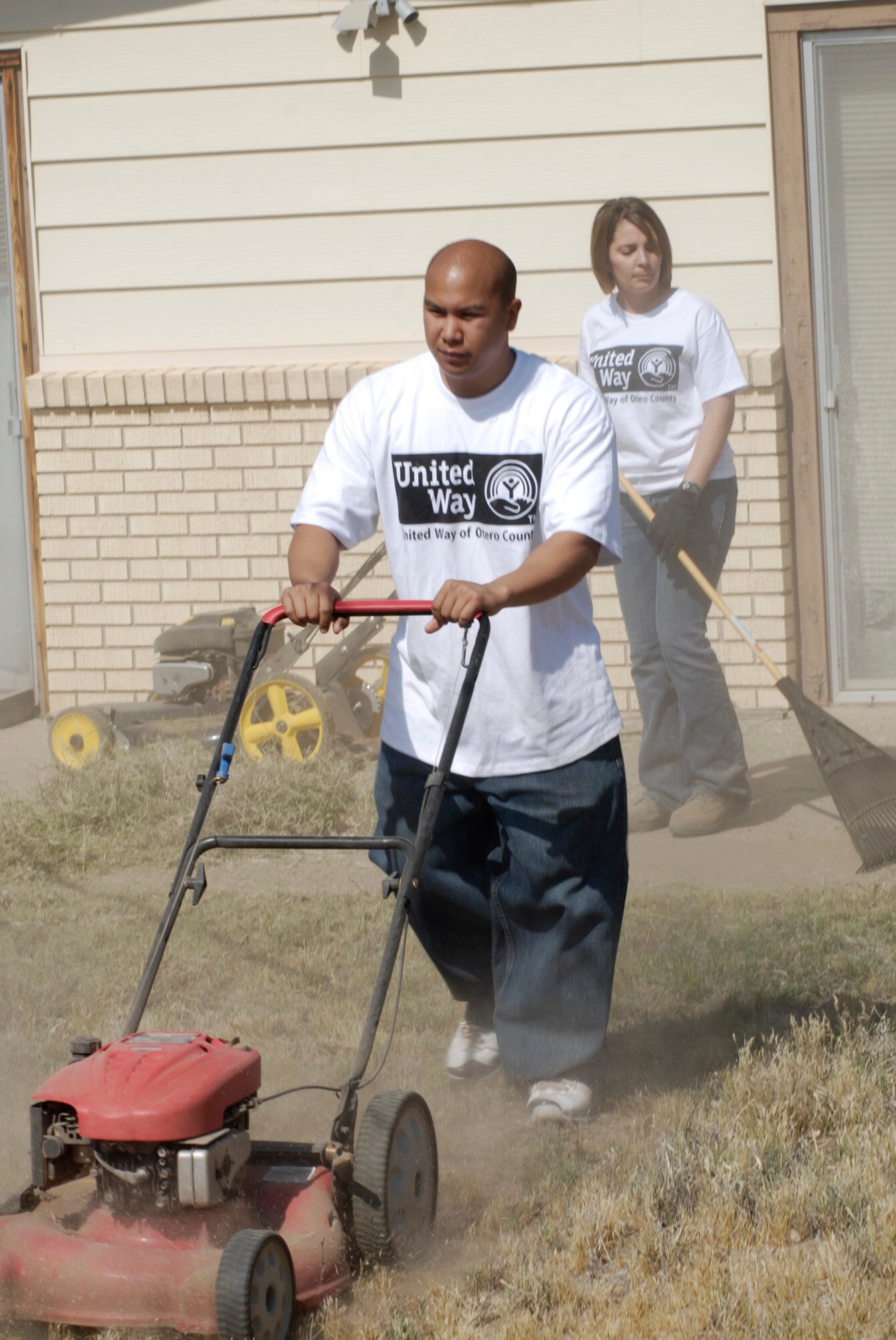 ALAMGORODO, N.M. -- Staff Sgt. Benjamin Laguana and Airman 1st Class Ashlee Labrie, both with the 49th Logistics Readiness Squadron at Holloman Air Force Base, work to clean up the backyard of a neglected home during the United Way Day of Caring May 14, 2010. This house was the second stop of the day for the team who worked two and a half hours before moving on to another assignment. (U.S. Air Force photo by Mr. Tom Fuller / Released)