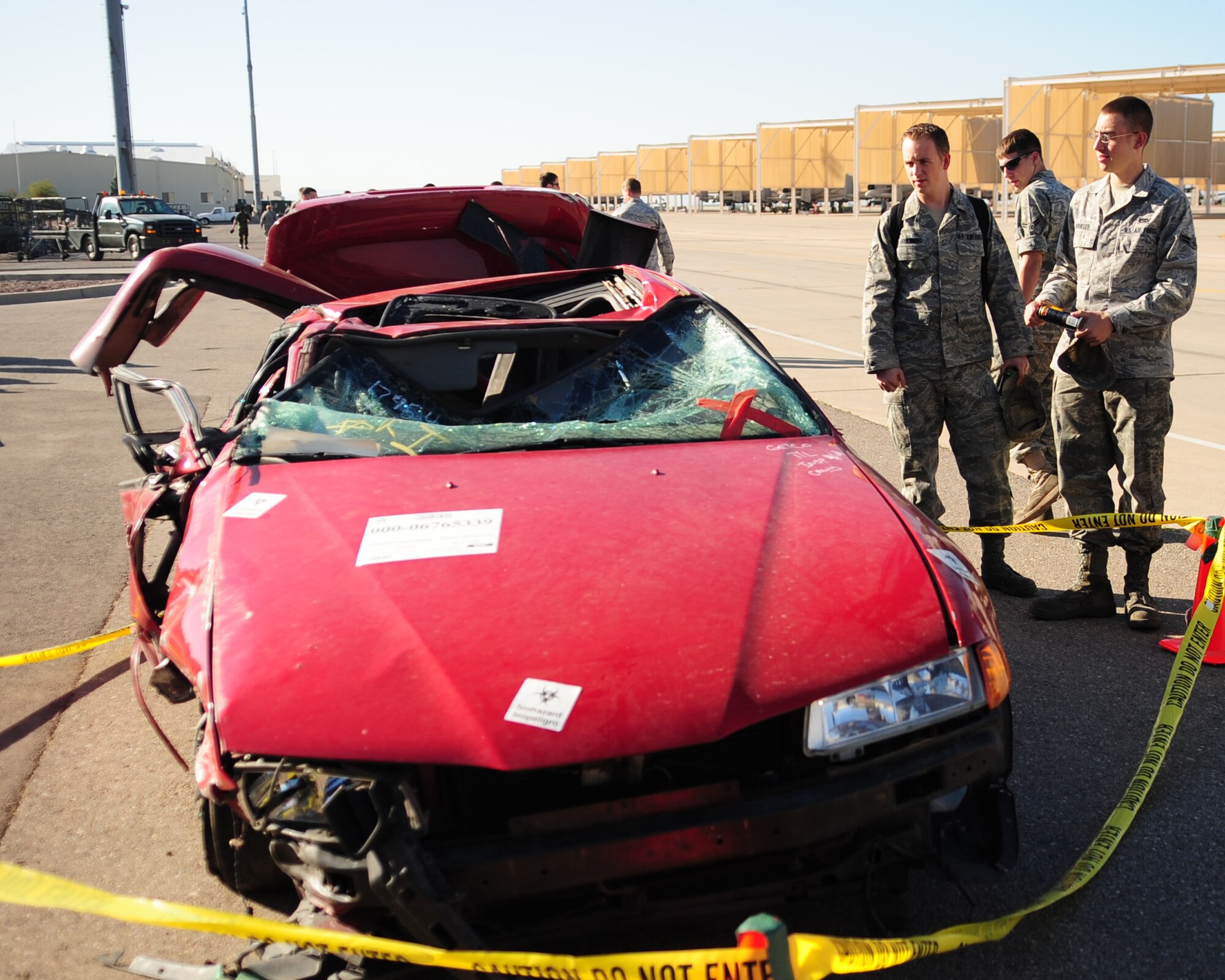 Airmen stop to take a look at a damaged car set on display during a Safety briefing here May 17. The car was involved in a mishap involving three airmen from D-M and was set on display to show the potential consequences of unsafe driving. Safety Day is an annual event hosted by the wing safety office and is meant to highlight and warn Airmen of the hazards associated with the “101 Critical Days of Summer.” (U.S. Air Force photo/Airman Jerilyn Quintanilla)