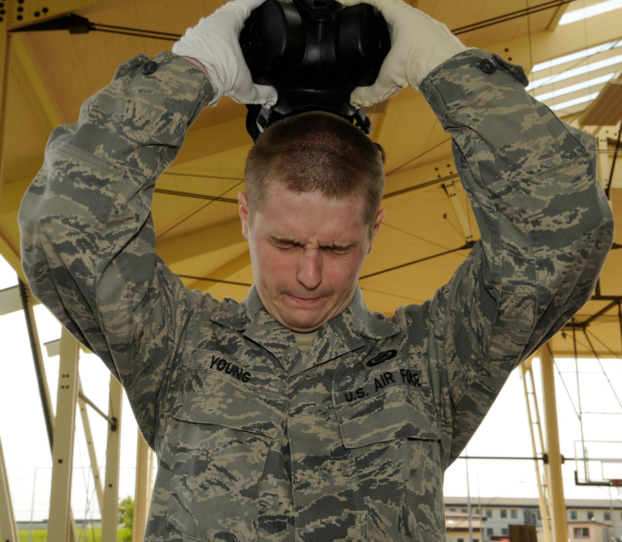 SPANGDAHLEM AIR BASE, Germany – Senior Airman Jeremy Young, 52nd Operations Group, removes his mask during the final step of processing through a contamination control area May 20. The purpose of this CCA was to train Airmen how to properly remove contaminated individual protective equipment after a chemical attack. (U.S. Air Force photo/Senior Airman Benjamin Wilson)