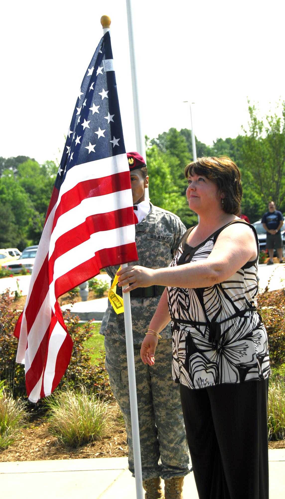 Mrs. Stacy Johnson, wife of Col. James Johnson, 43rd Airlift Wing Commander, places a flag in honor of Senior Airman Ashton Goodman at the Field of Honor event at the Airborne Special Operations Museum May 15. Airman Goodman was deployed from Pope to Afghanistan when her convoy was struck by an Improvised Explosive Device, May 2009. (U.S. Air Force photo/2nd Lt. Cammie Quinn)
