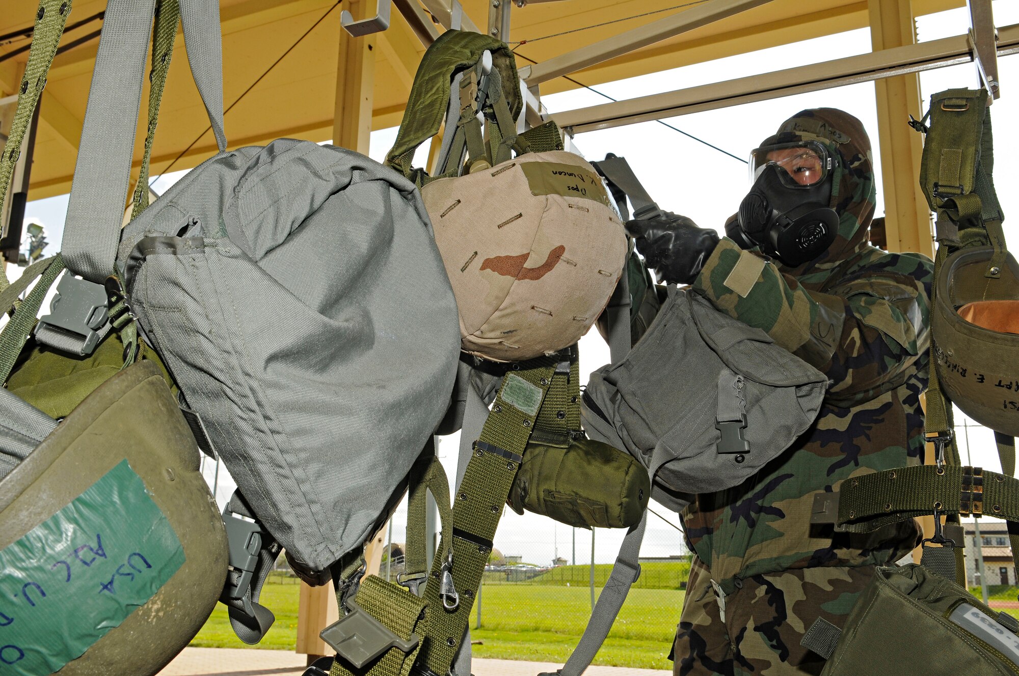 SPANGDAHLEM AIR BASE, Germany – Airman 1st Class Raymond Kim, 52nd Component Maintenance Squadron, hangs his external equipment on a rack at the first station of a contamination control area during training May 20. Airman Kim volunteered to process through the CCA in preparation for the upcoming NATO Force Evaluation. (U.S. Air Force photo/Senior Airman Benjamin Wilson)