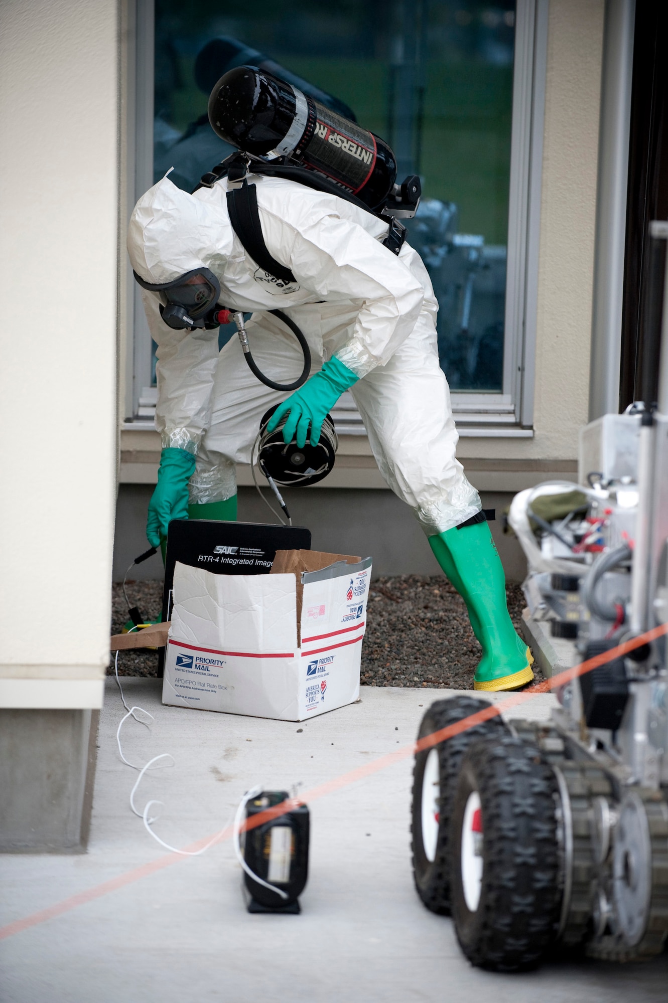 MISAWA AIR BASE, Japan -- Staff Sgt. Nathan Lentsch, 35th Civil Engineer Squadron explosive ordnance disposal technician, sets up a portable digital X-Ray scanner around a simulated suspicious package during an emergency management exercise at the Richard Bong Theater May 19. The X-Ray scanner allowed Sergeant Lentsch to see inside the box to determine its contents for proper disposal. (U.S. Air Force photo/Staff Sgt. Samuel Morse)